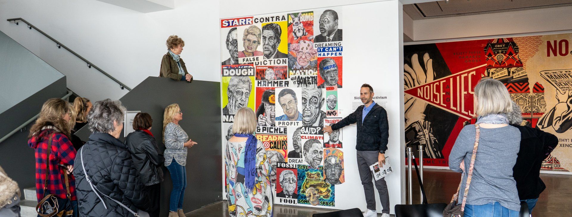 A group of people are standing in front of a wall covered in stickers.