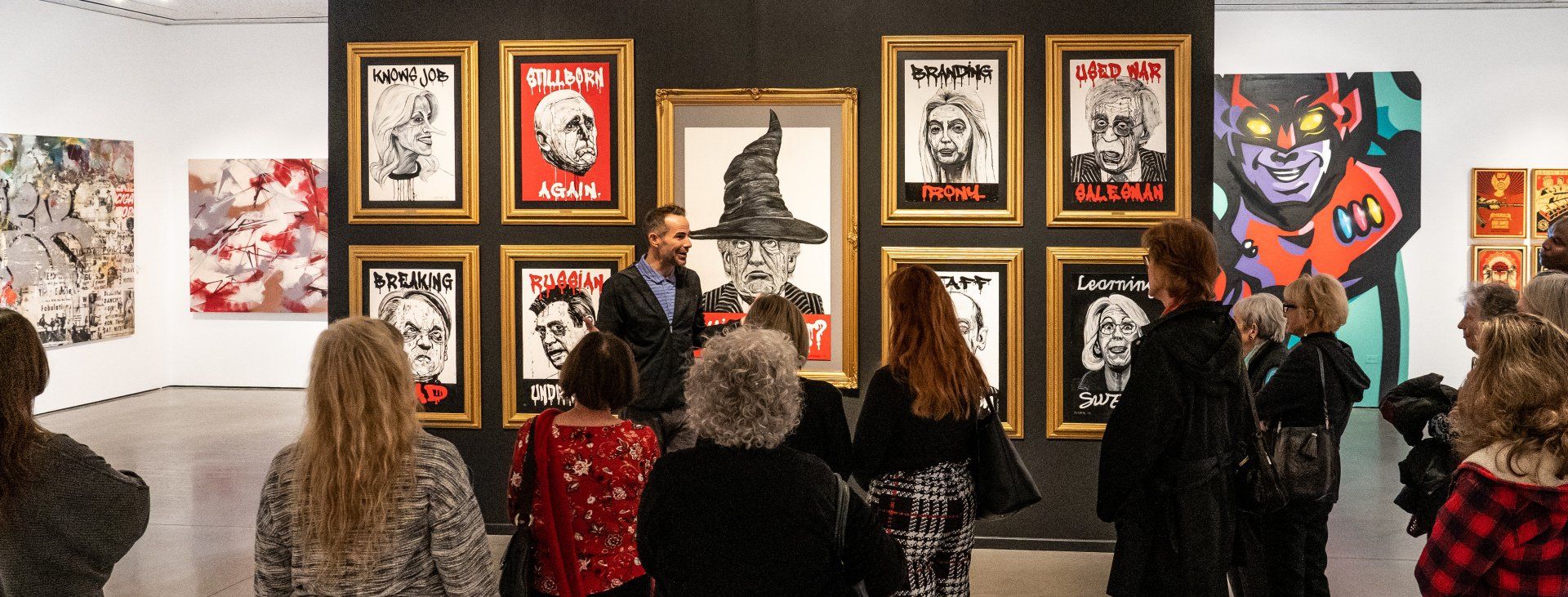 A group of people are looking at paintings in Track 16 Gallery.