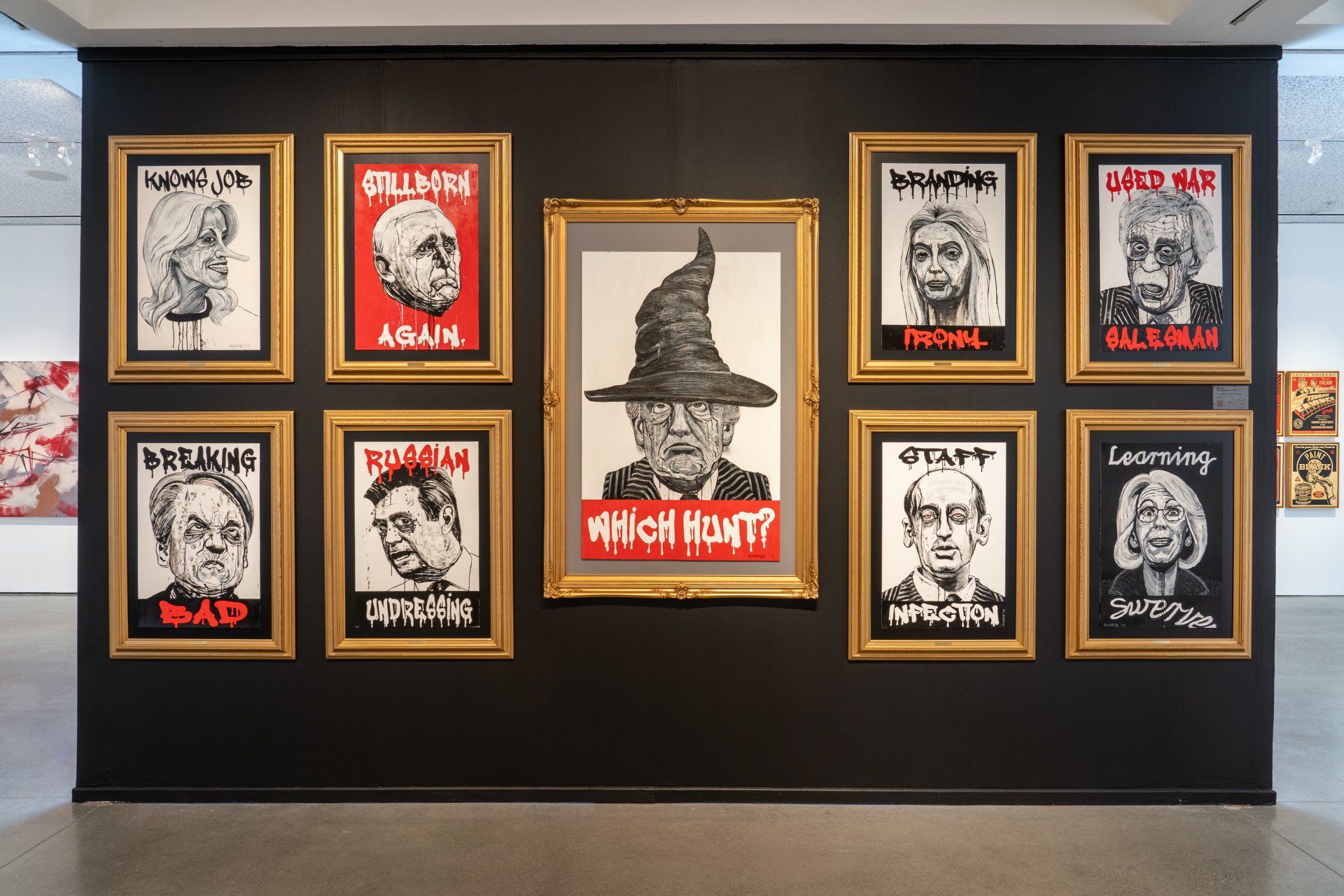 A wall with a bunch of framed pictures of people on it.