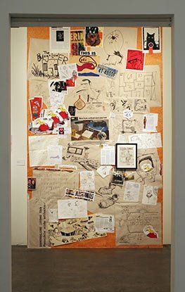 A wall with a lot of pictures and drawings on it.