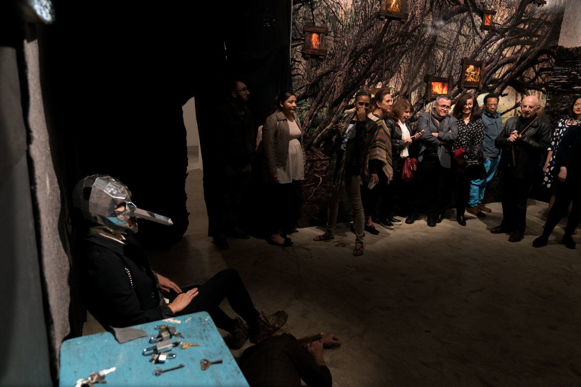 A group of people are standing around a table in a dark room.
