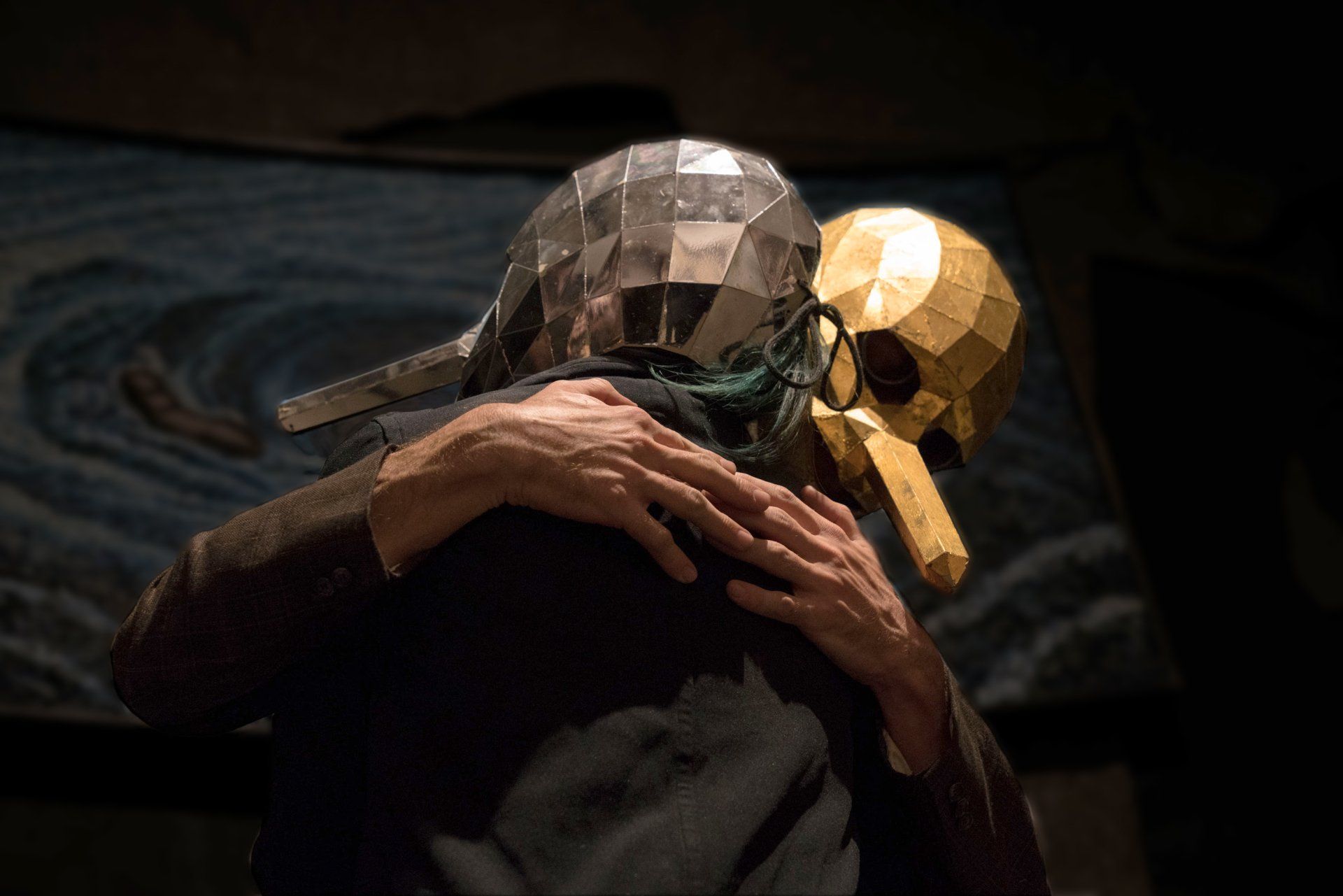 A person wearing a skull mask is hugging another person.