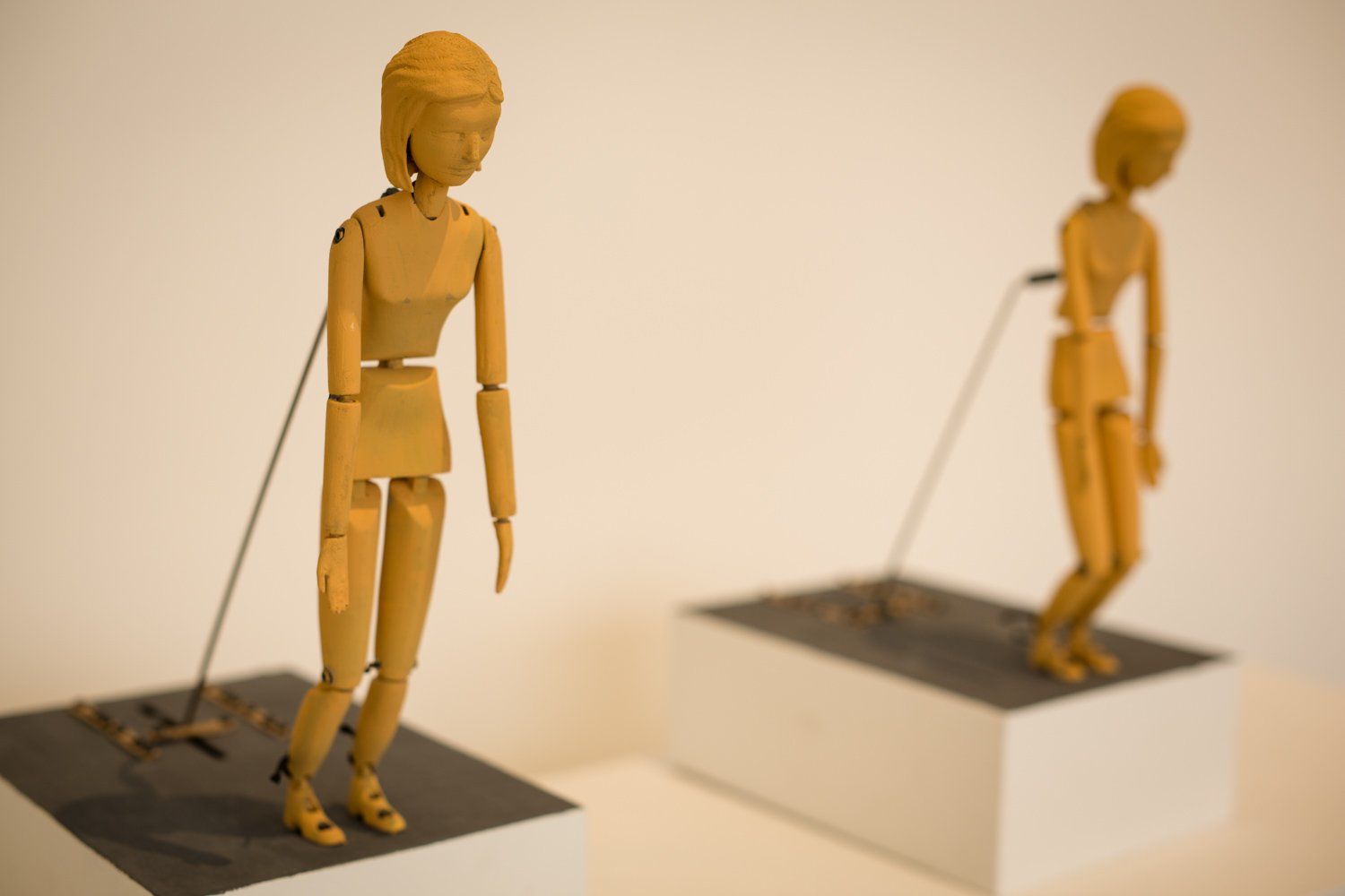 Two wooden mannequins are standing next to each other