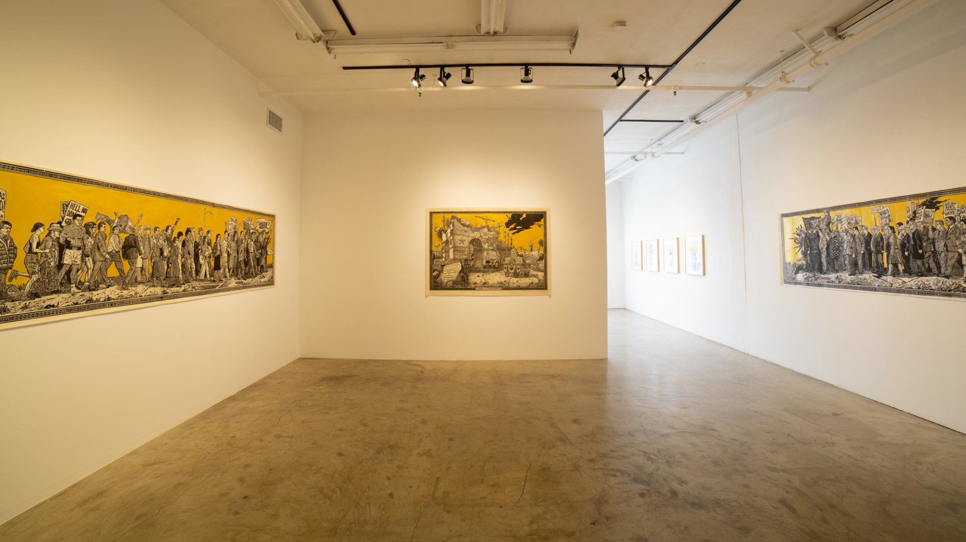 A large empty room with a lot of paintings on the wall.