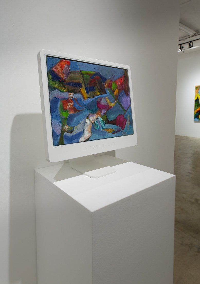A computer monitor with a colorful painting on it