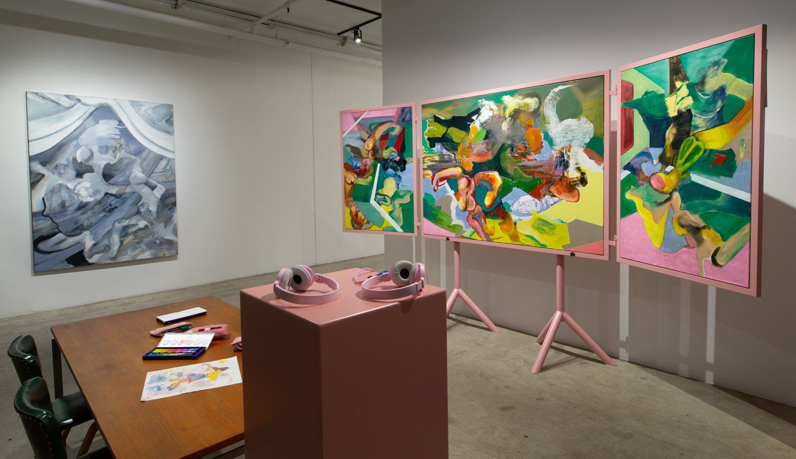 A room with a table , chairs , and paintings on the wall.