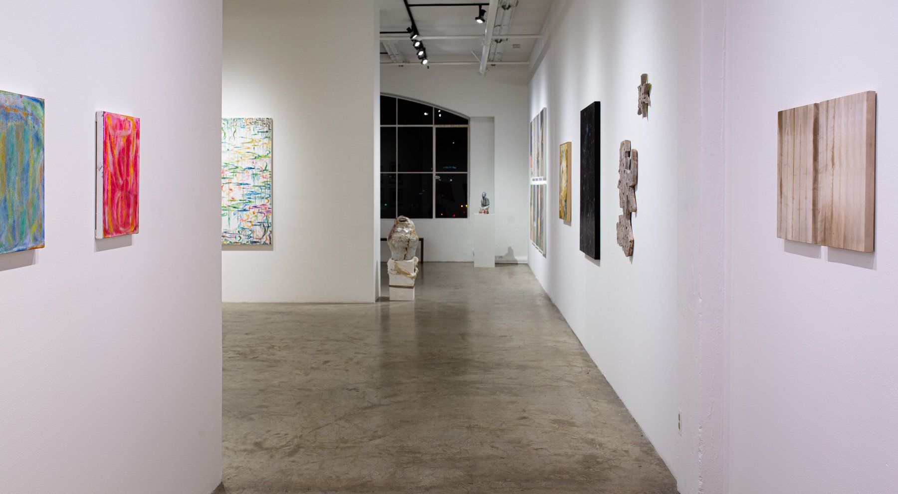 A long hallway in Track 16 Gallery with paintings on the wall.