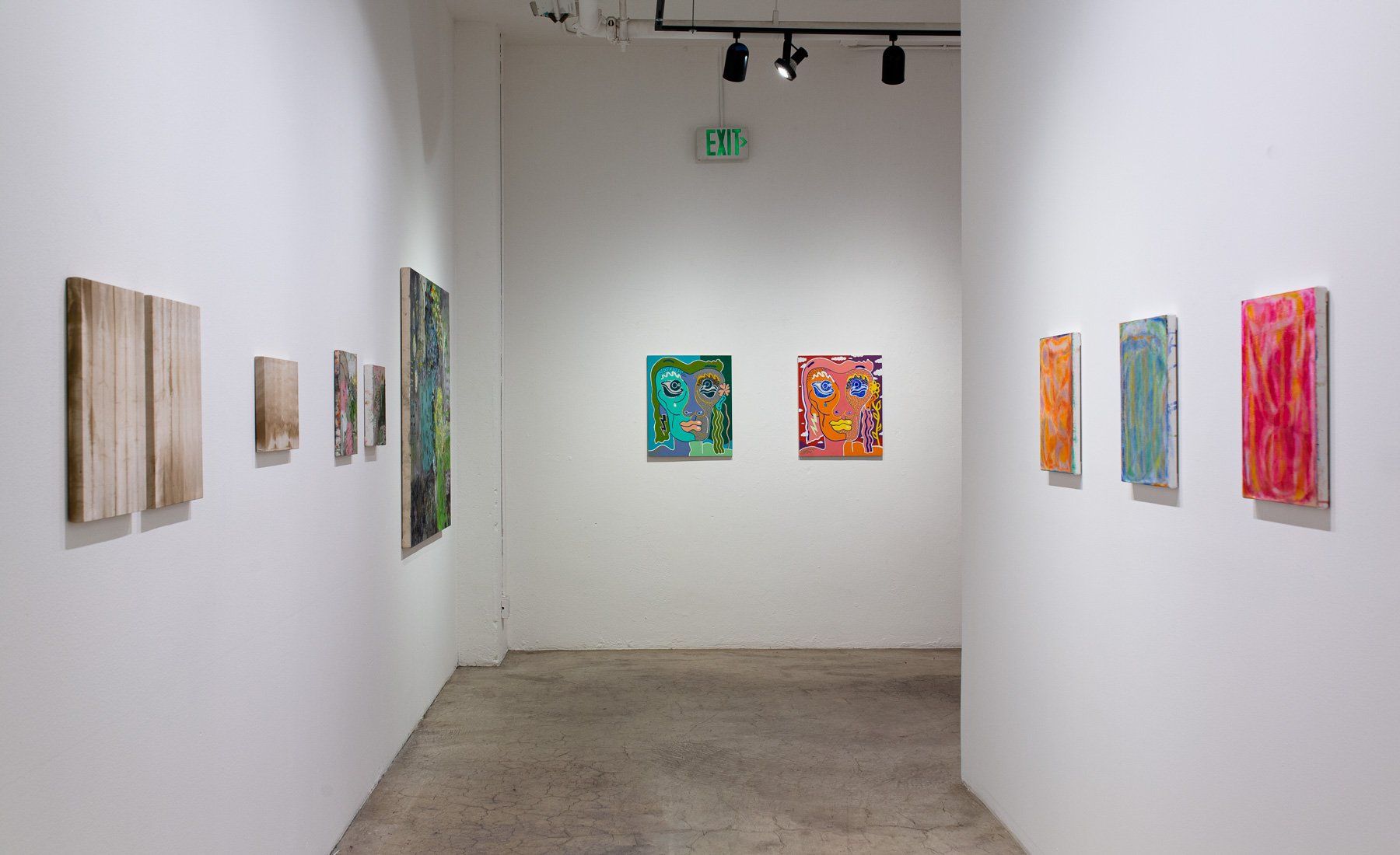 A long hallway with paintings on the wall in Track 16 Gallery.