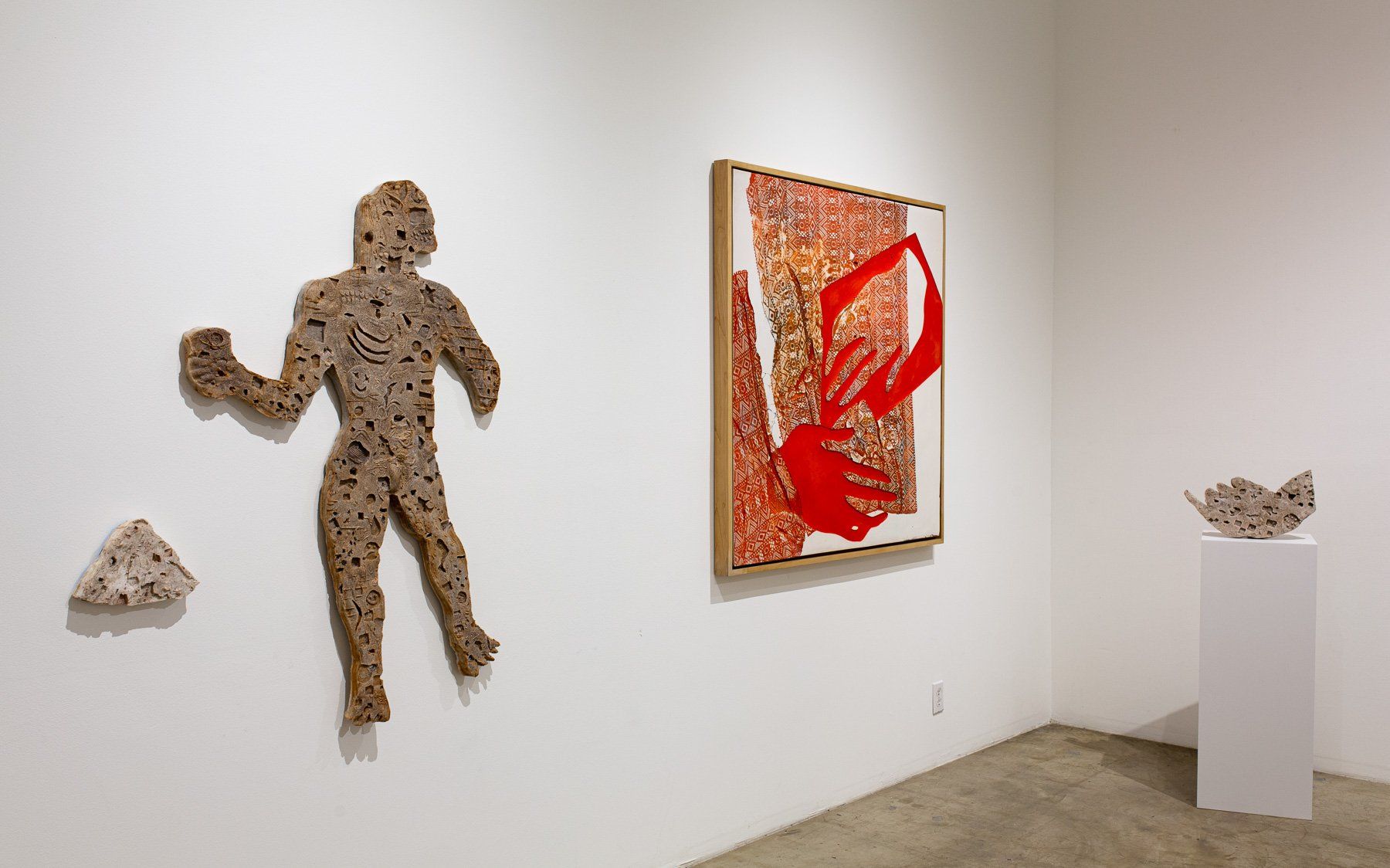 A room with a statue of a man and a painting on the wall.