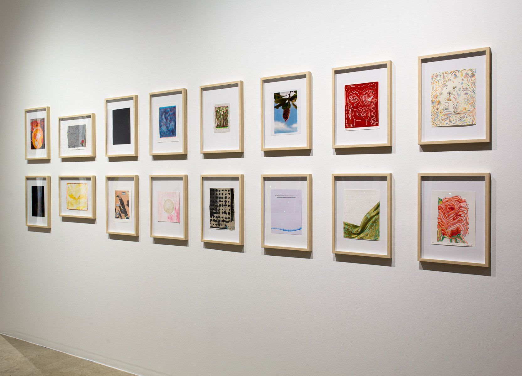 A row of framed pictures on a wall in a museum.