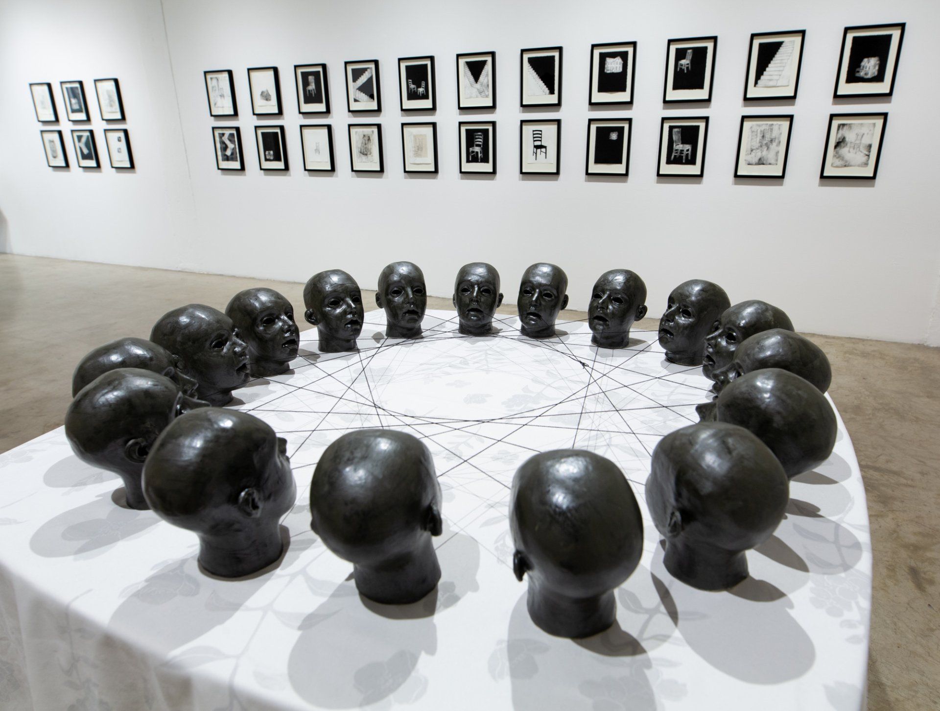 A table with a circle of heads on it in a museum.