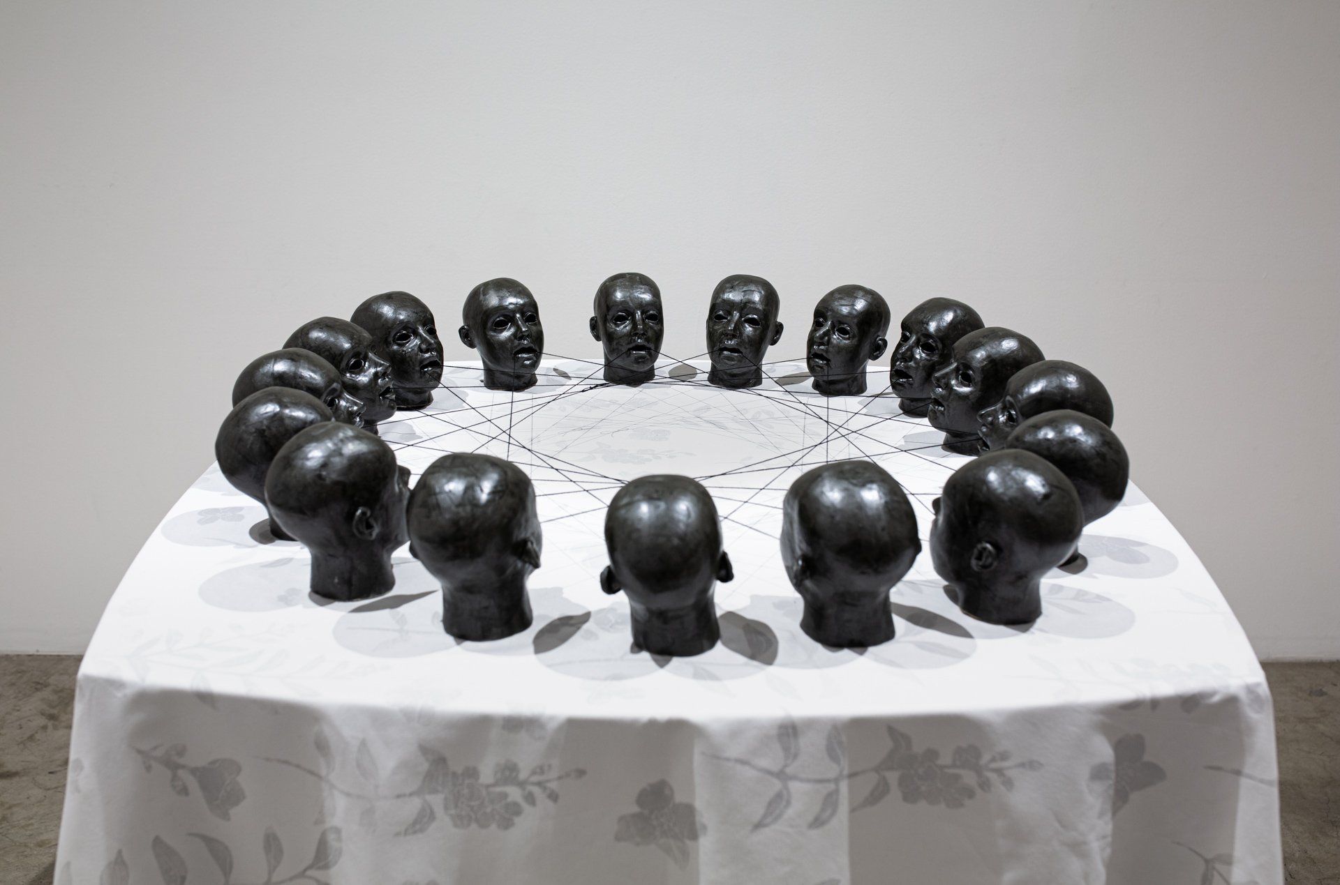 A table with a circle of black heads on it