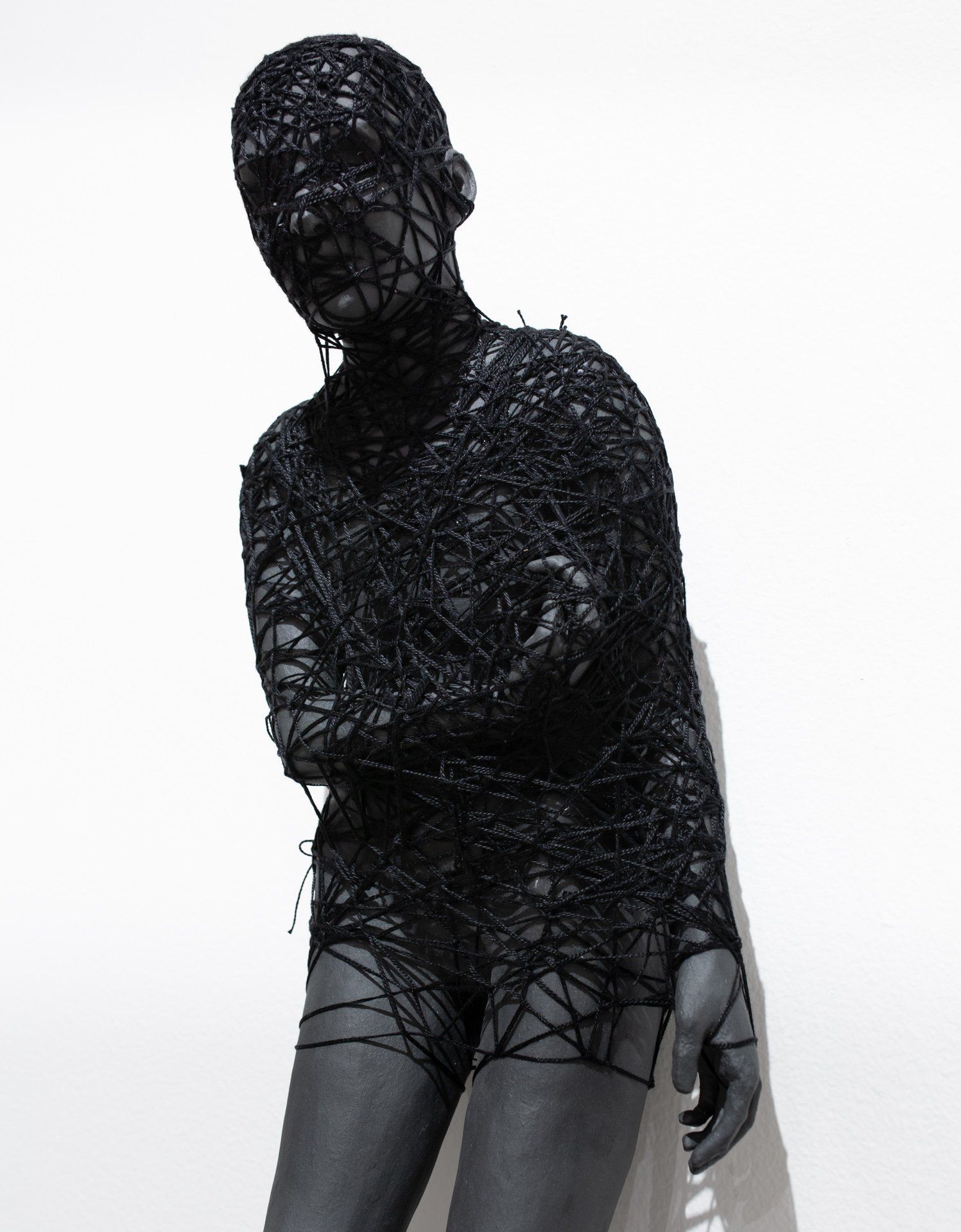 A statue of a woman in a black lace bodysuit