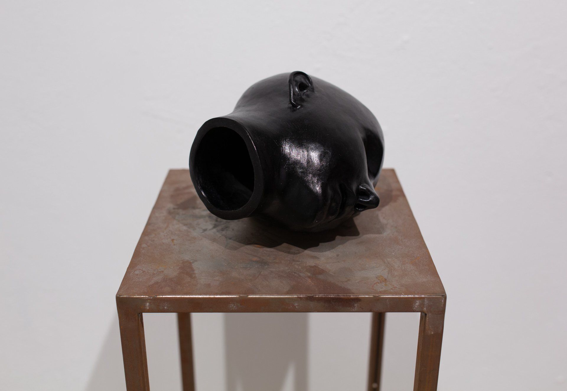 A black sculpture is sitting on a small table