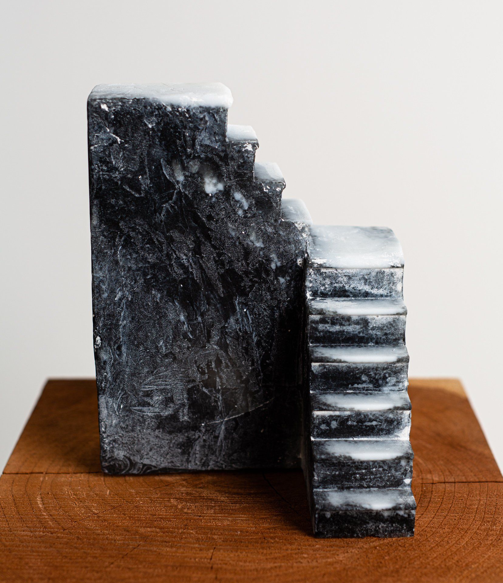 A black and white sculpture of stairs is sitting on a wooden table.