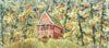 A red house is sitting in the middle of a field surrounded by trees.