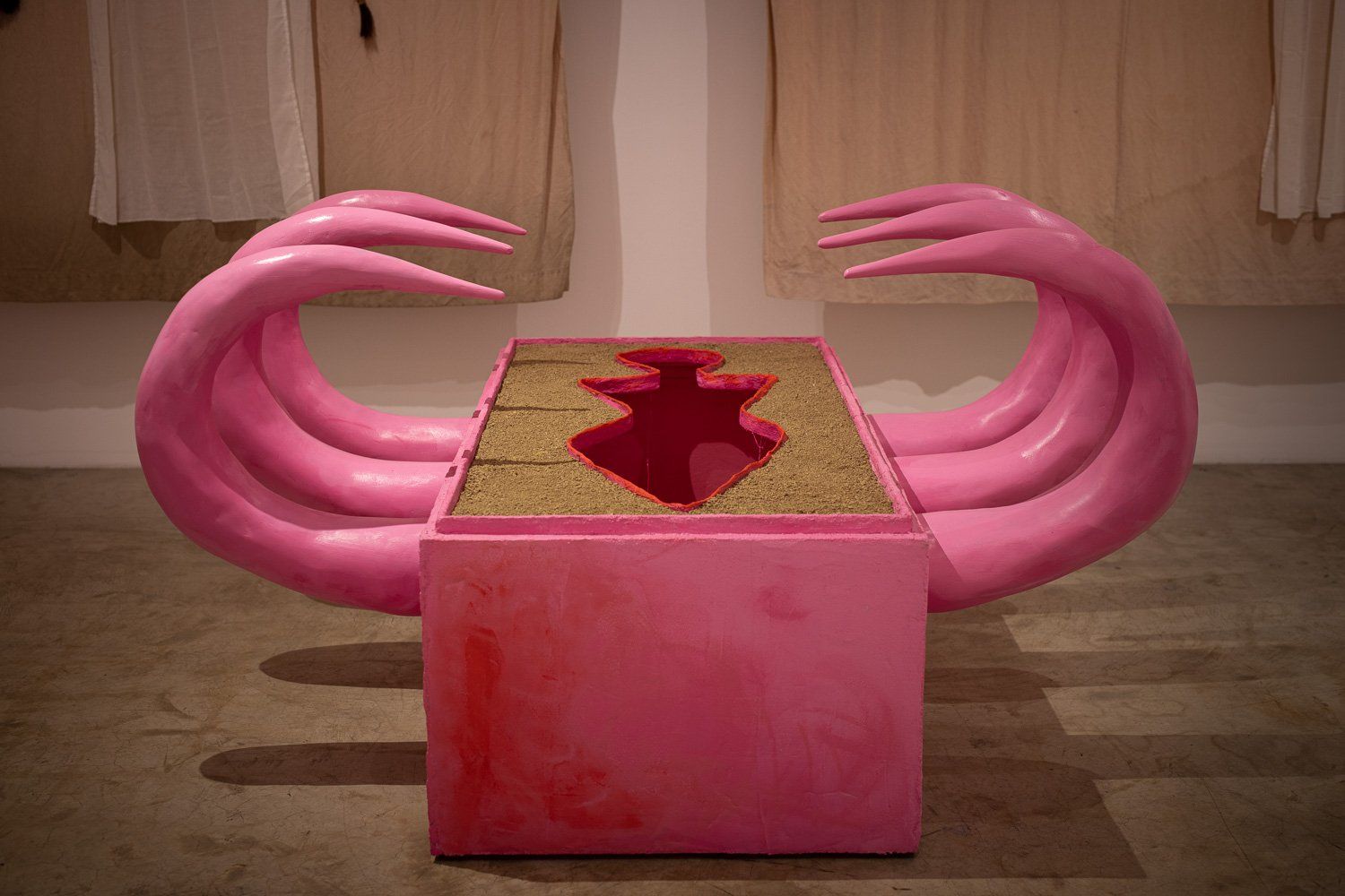 A pink sculpture with a hole in the middle of it.