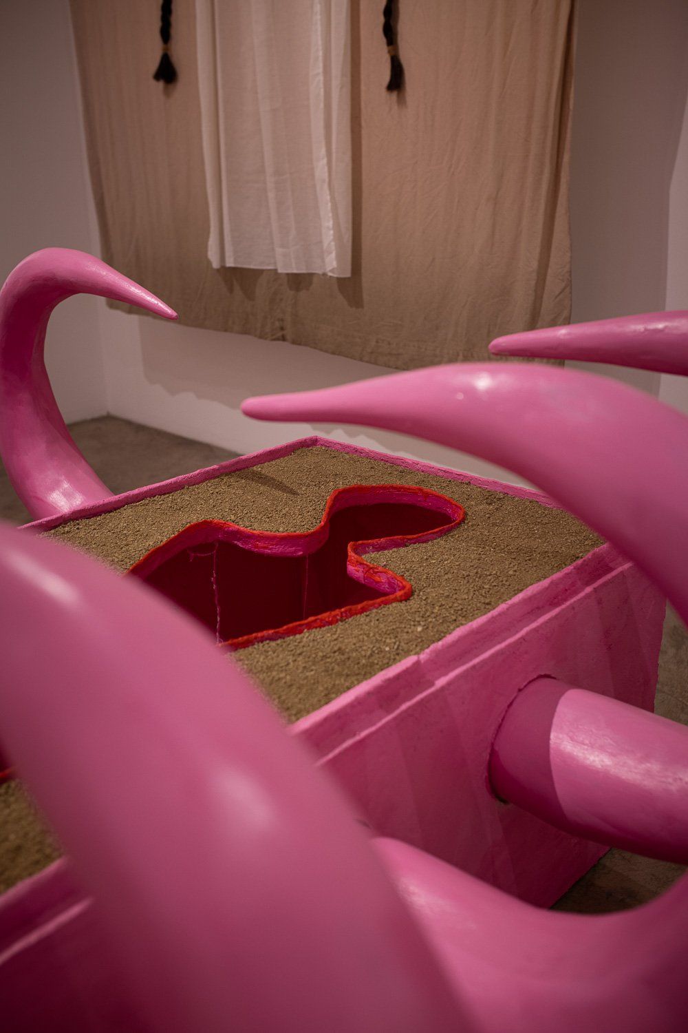 A pink sculpture with a hole in the middle of it.