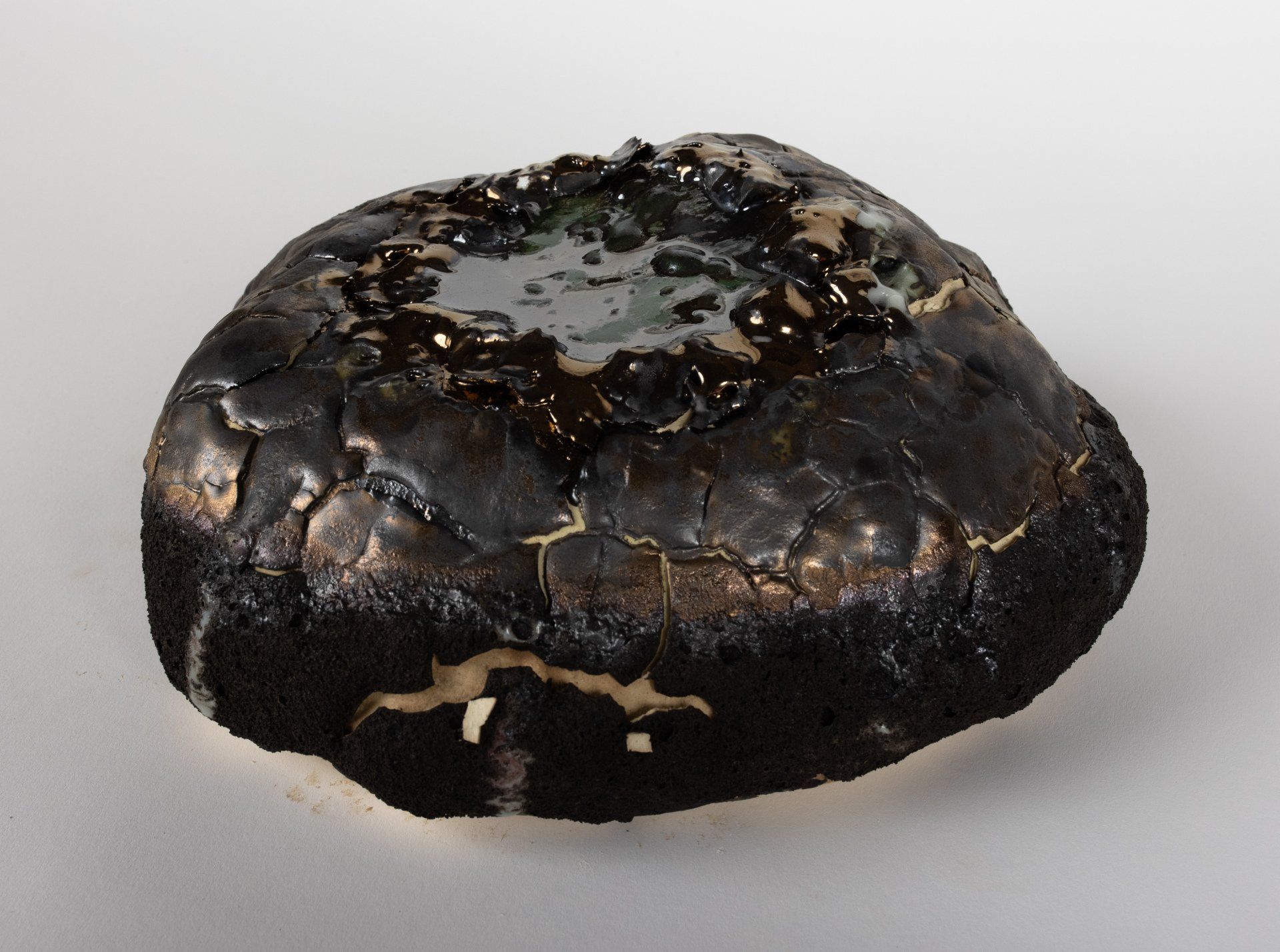 A close up of a black rock on a white surface
