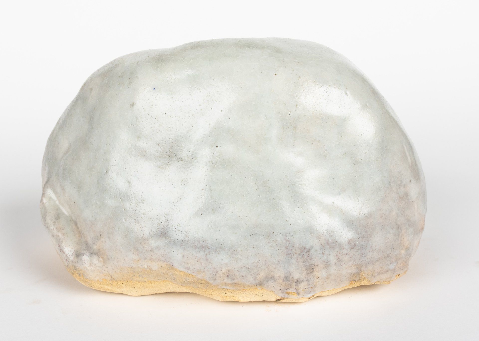 A close up of a white rock on a white surface.
