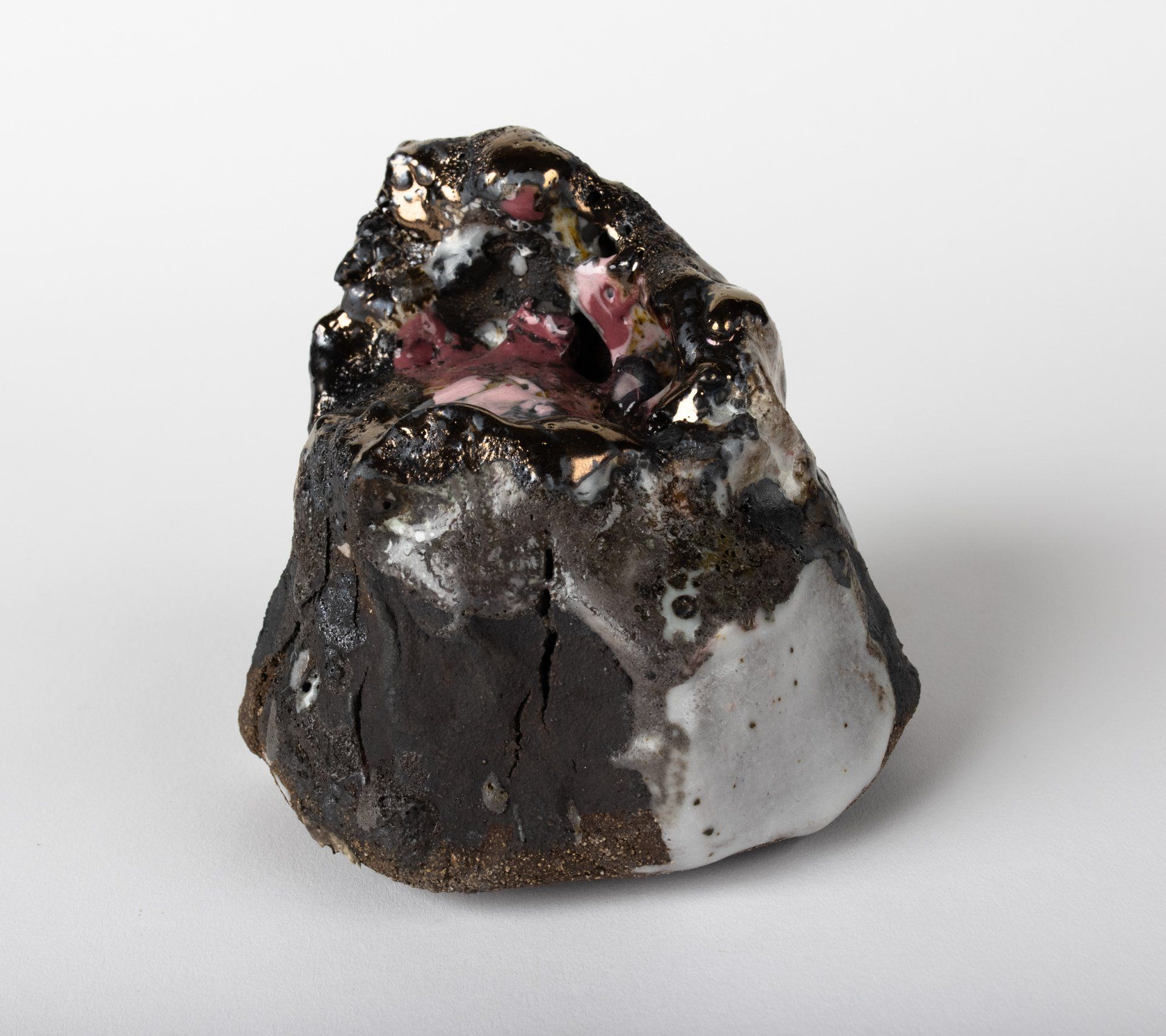 A small black and white rock on a white surface