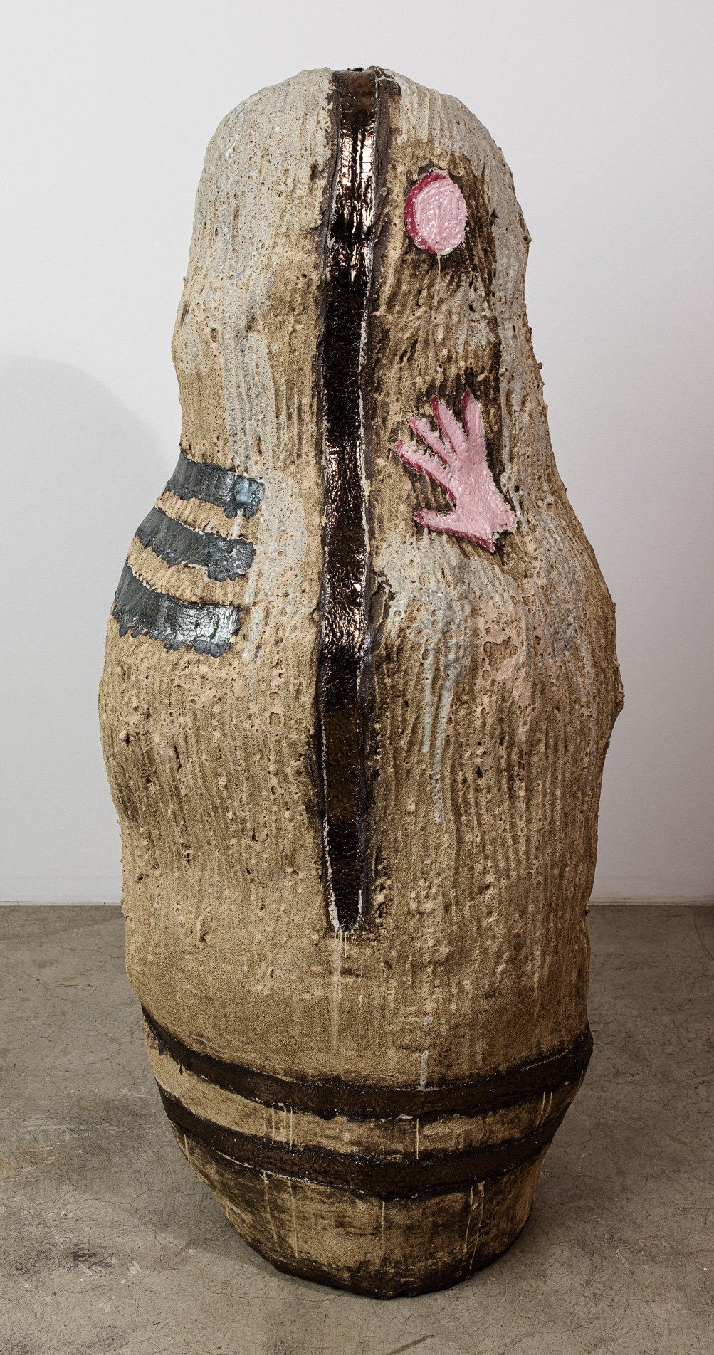 A large ceramic sculpture with a hand sticking out of it.
