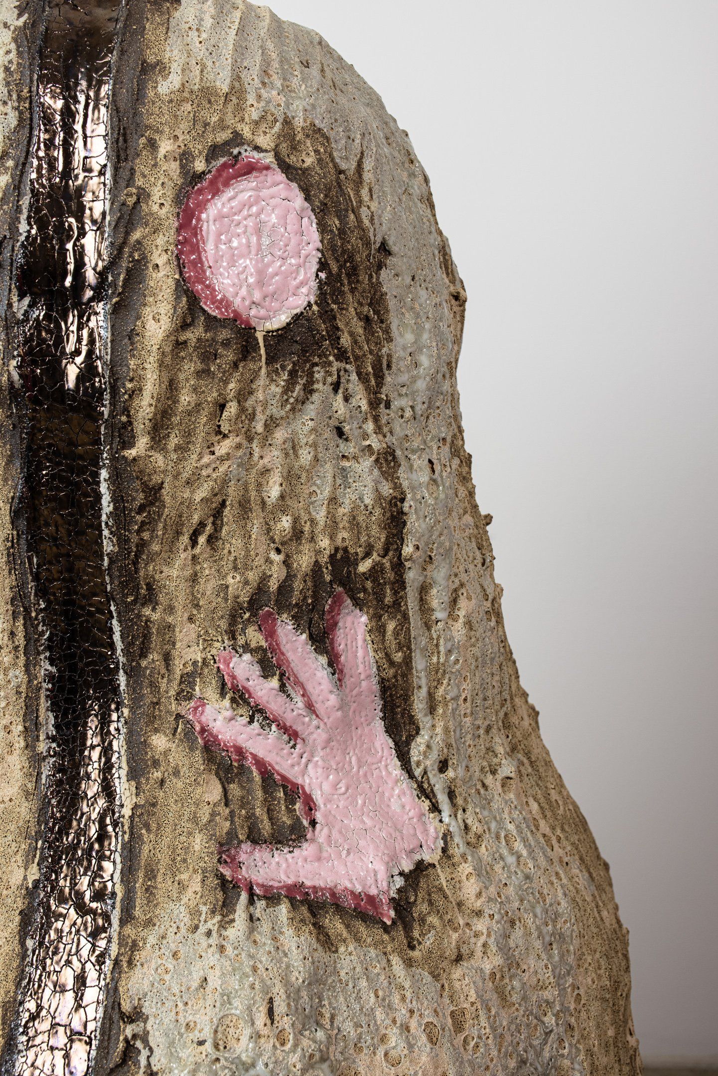 A close up of a sculpture with a pink hand on it.