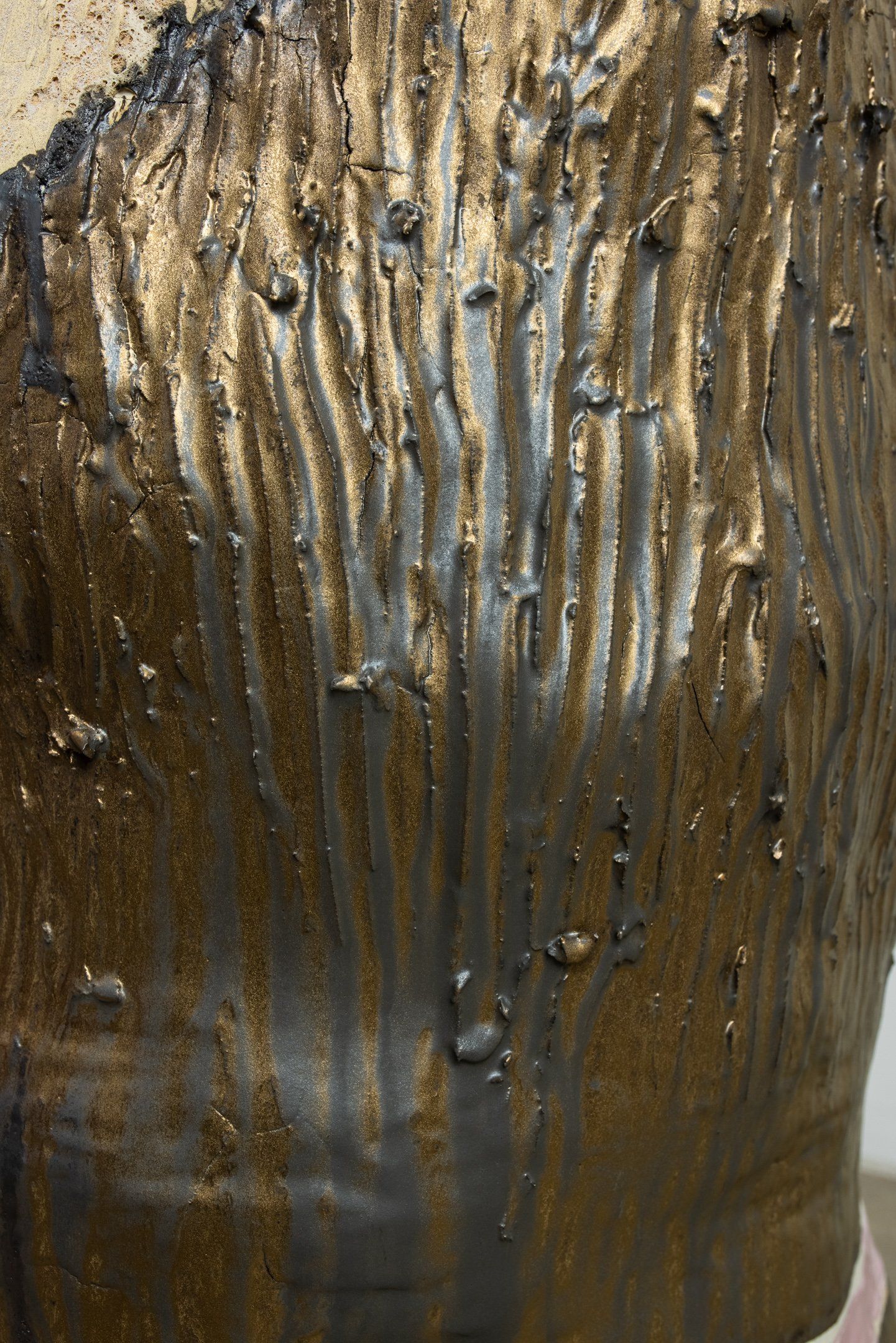 A close up of a brown and gold painting on a vase.