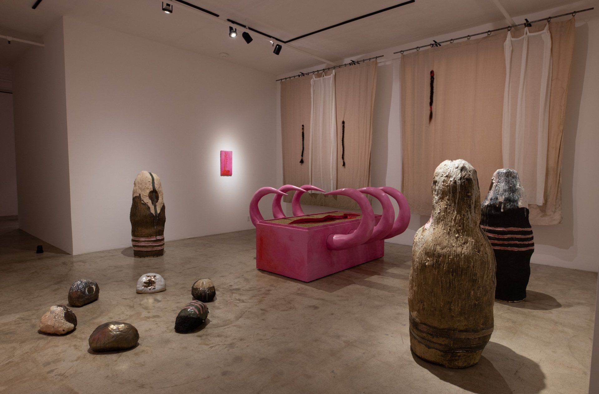A room filled with lots of sculptures and a pink couch.