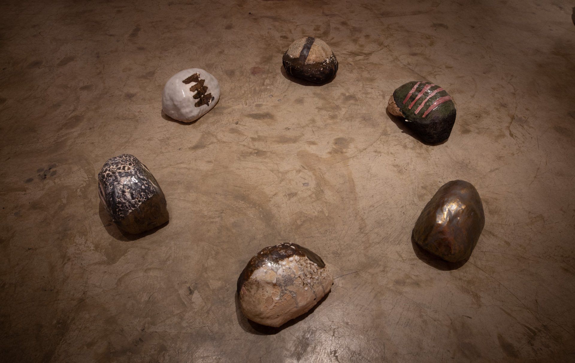 A group of rocks are sitting in a circle on the ground.