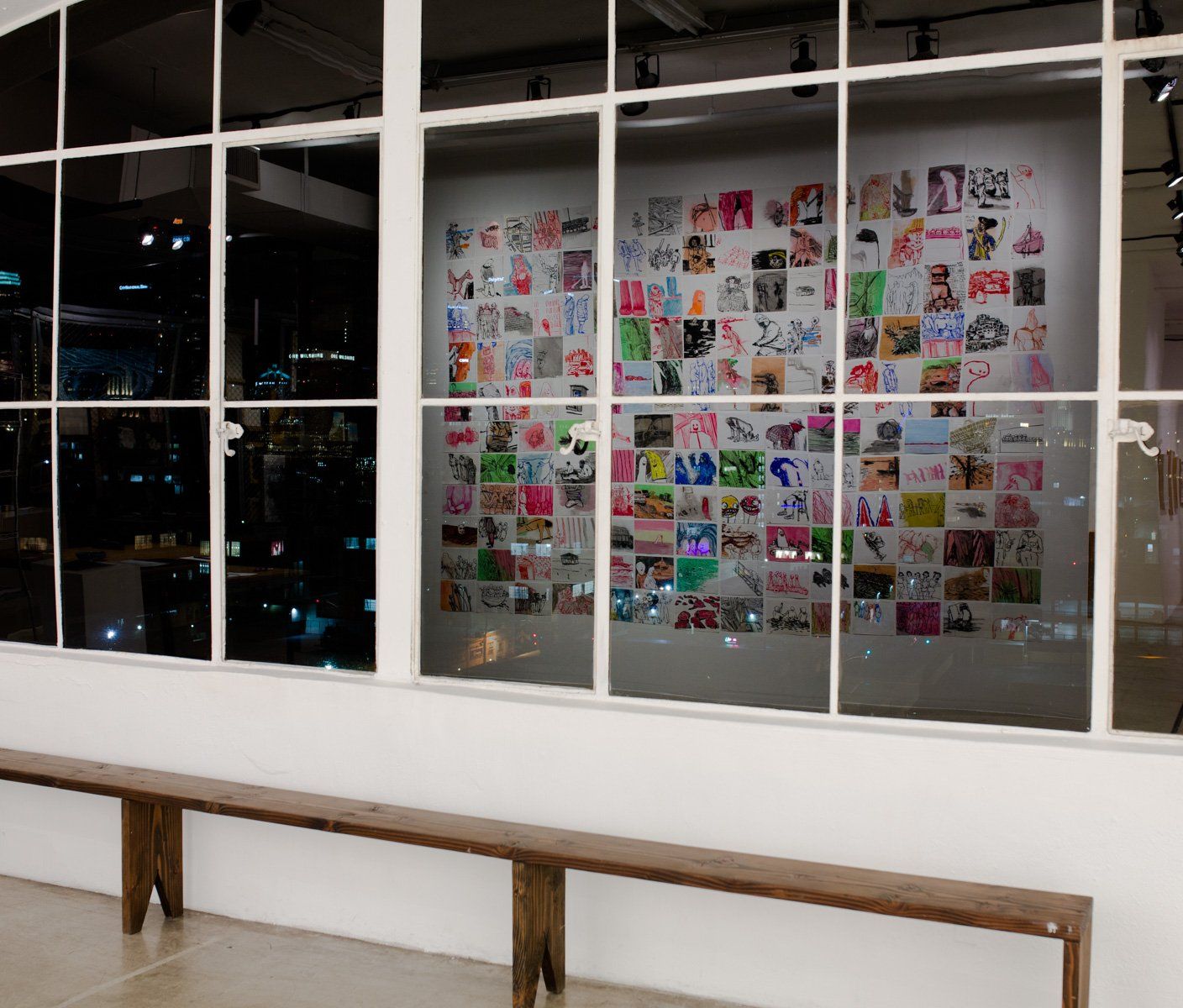 A wall with a lot of pictures on it and a bench in front of it