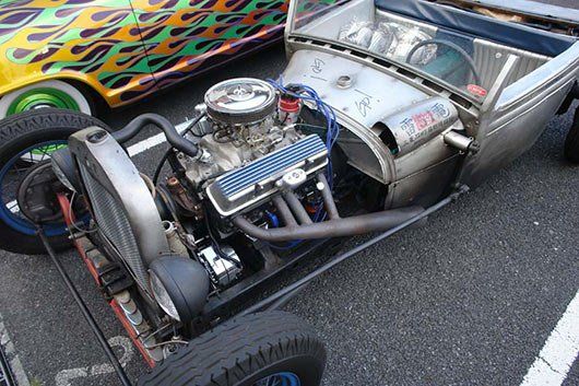 A close up of a car engine in a parking lot