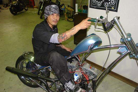A man is working on a motorcycle in a garage.