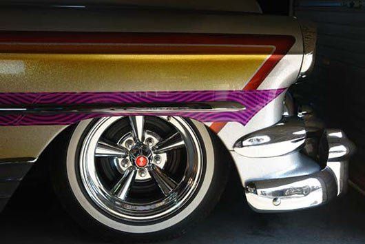 A close up of a car 's wheel with white tires