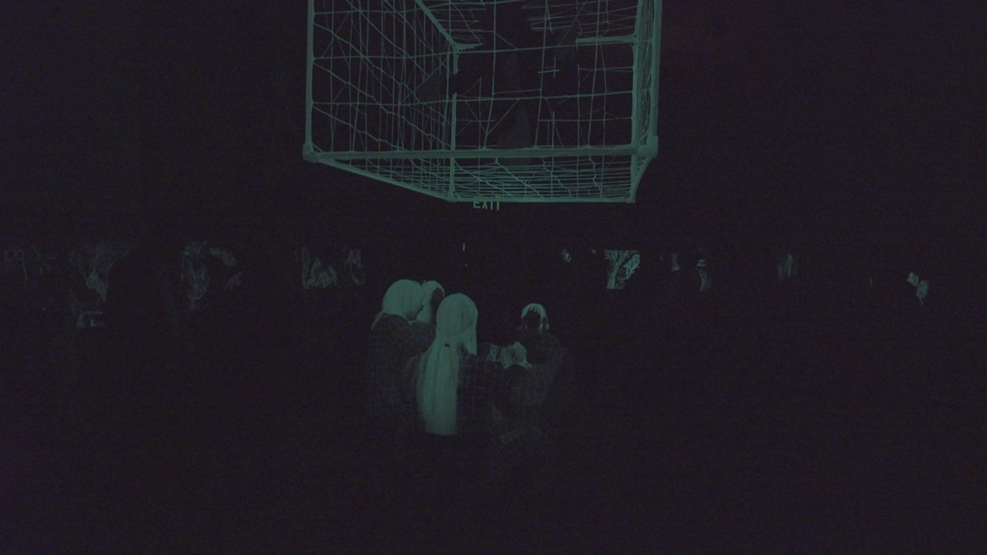 A group of people are standing in a dark room.