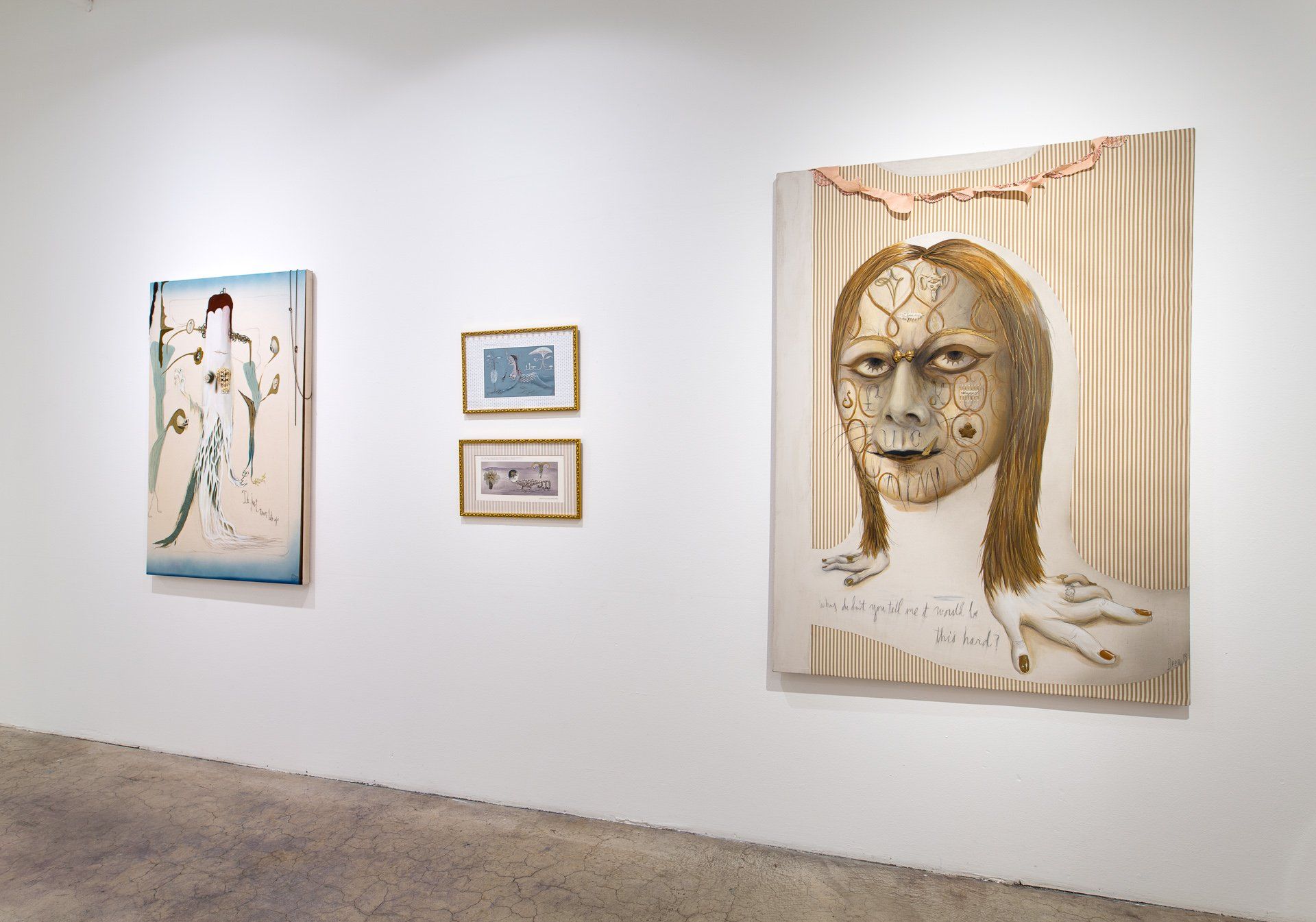 A room with a painting of a woman 's face on the wall.