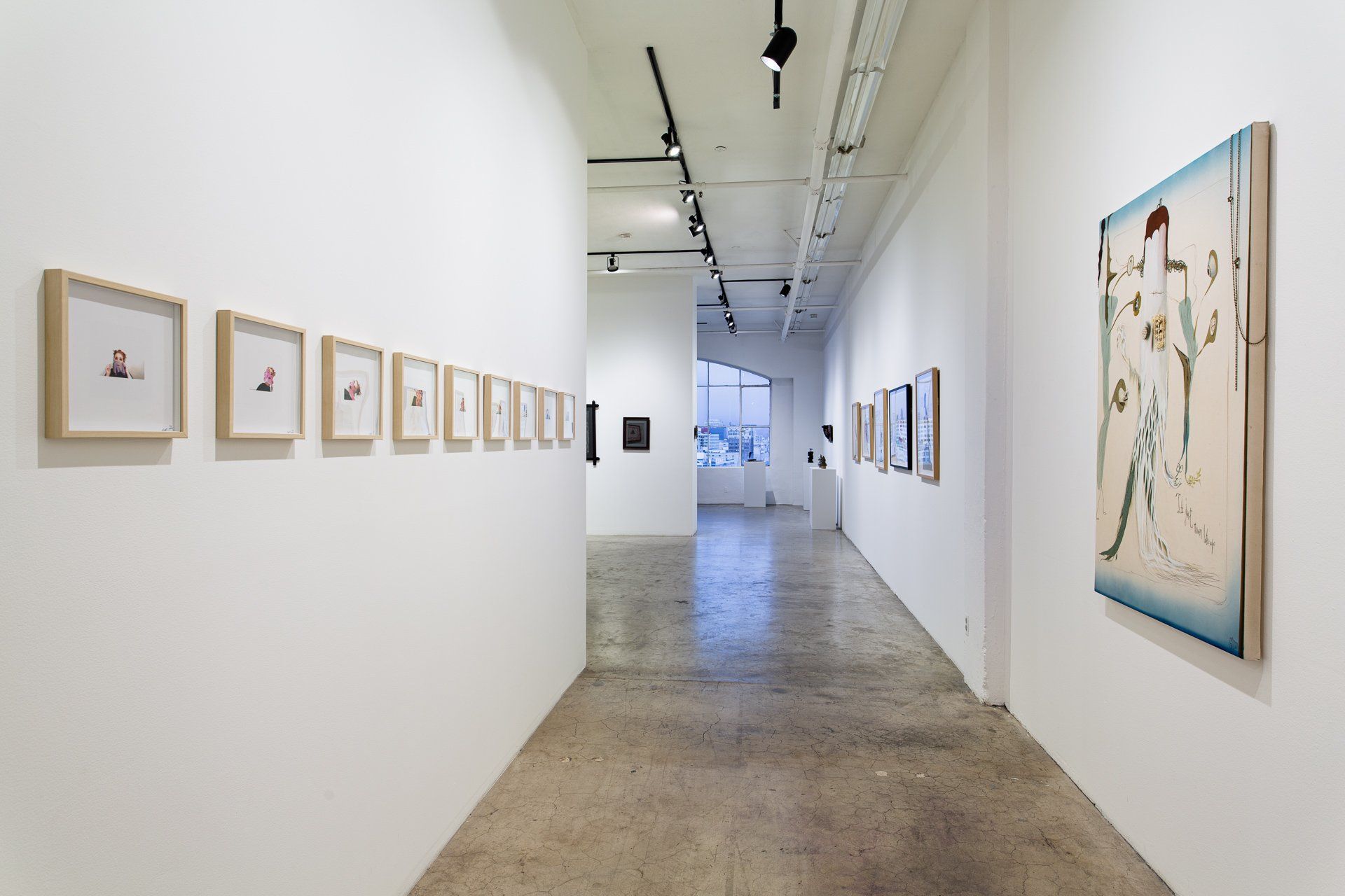 A long hallway in a museum with paintings on the wall.