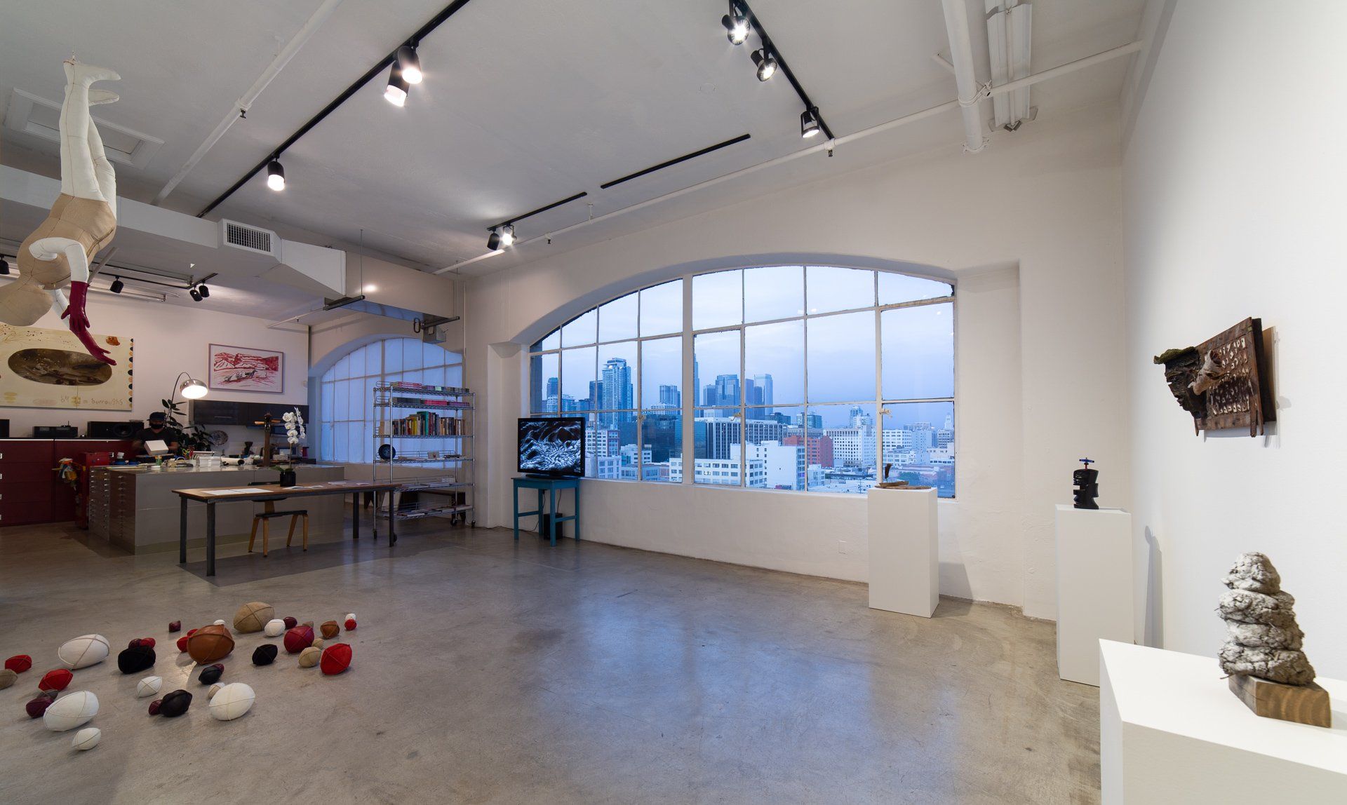 A large empty room with a large window and a lot of sculptures on the floor.