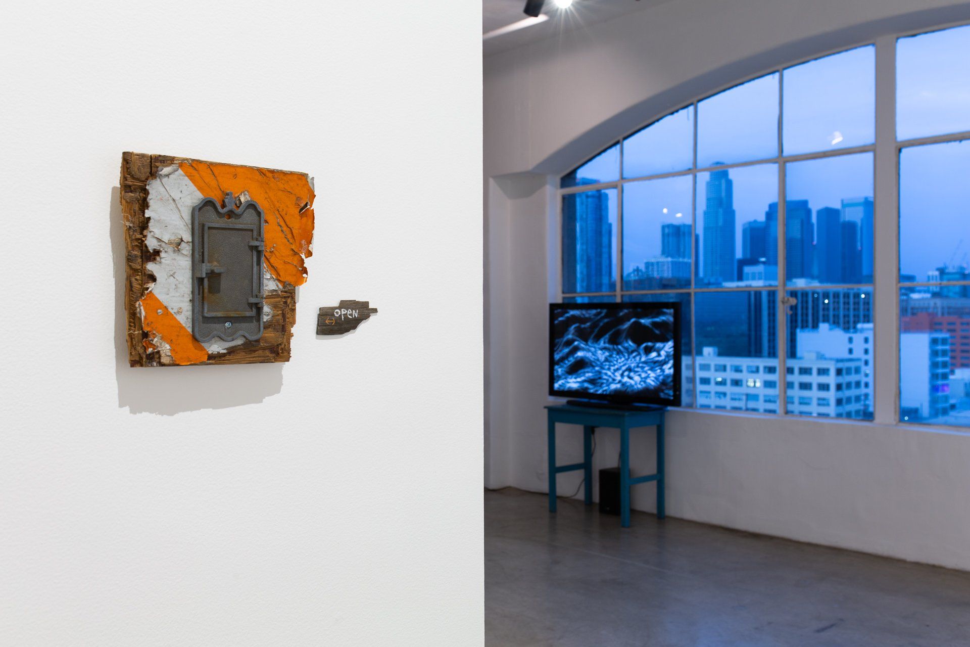 A picture of a painting on a wall next to a picture of a television in a room.