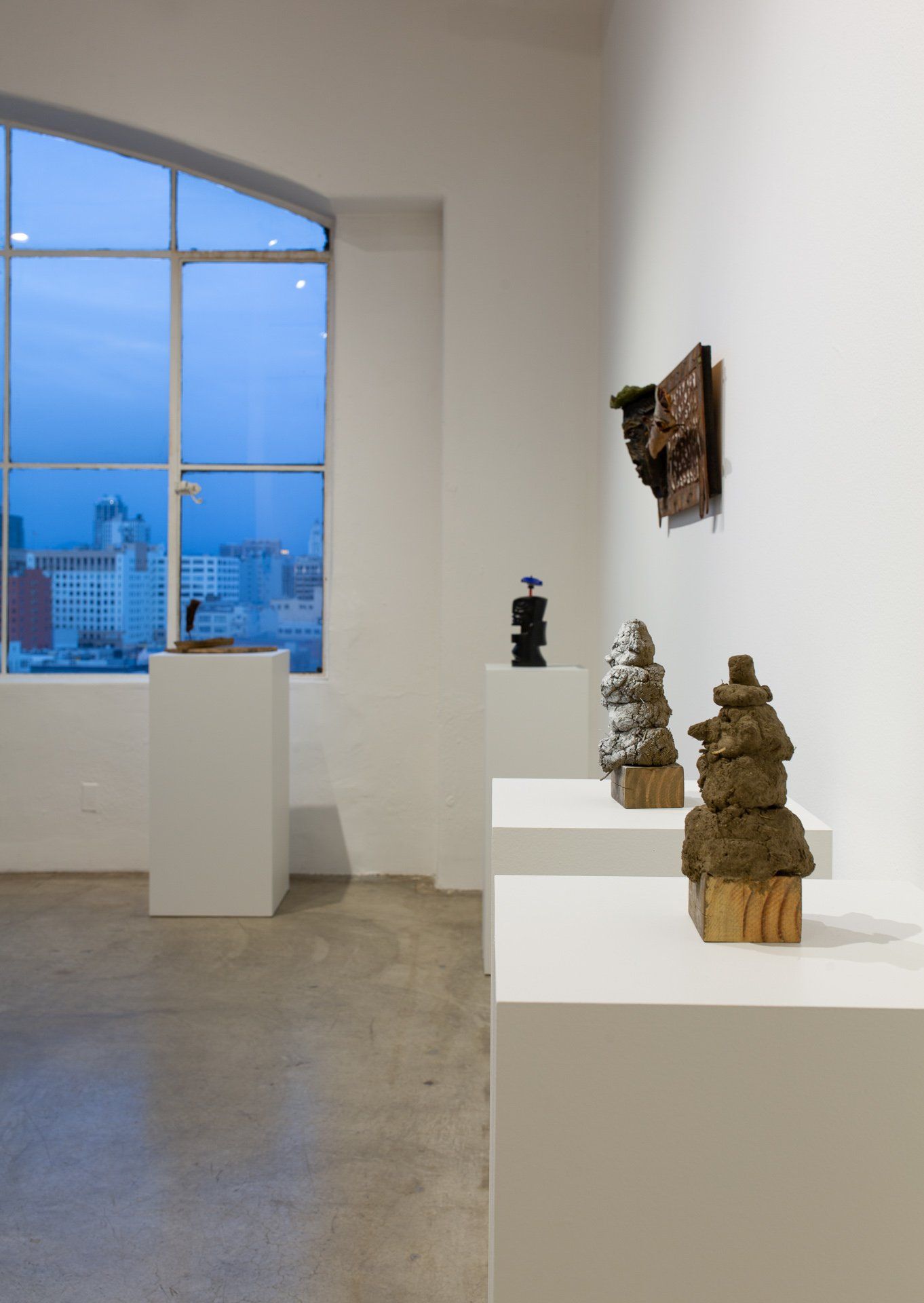 A room with a lot of sculptures on display and a window