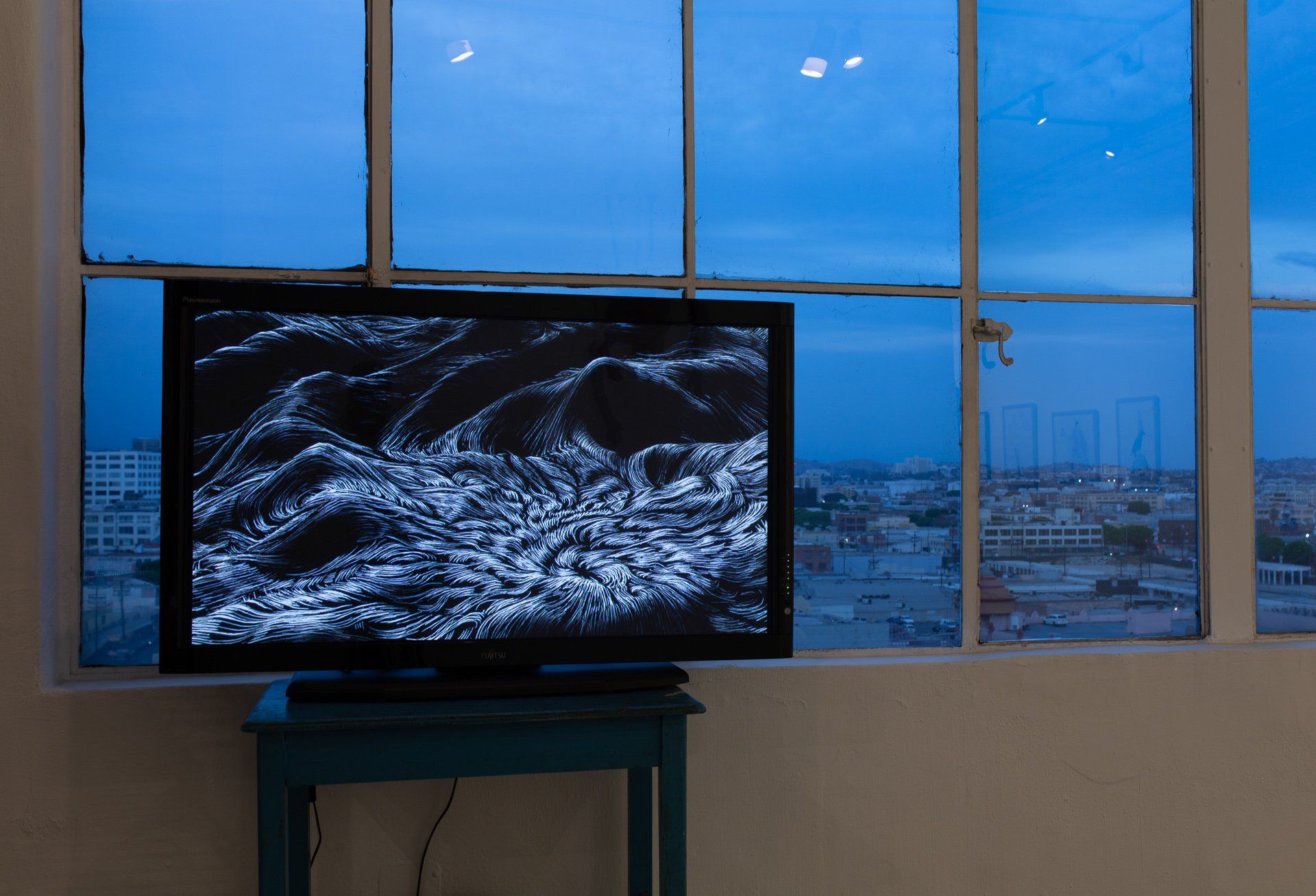 A flat screen tv is sitting on a table in front of a window