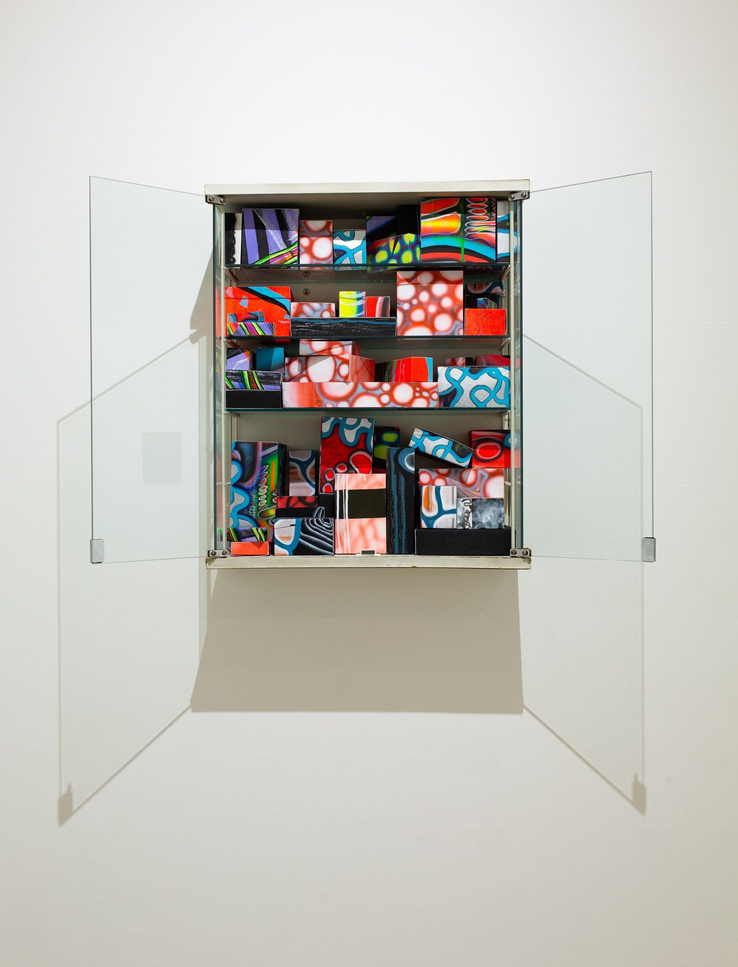 A cabinet with a lot of colorful boxes in it