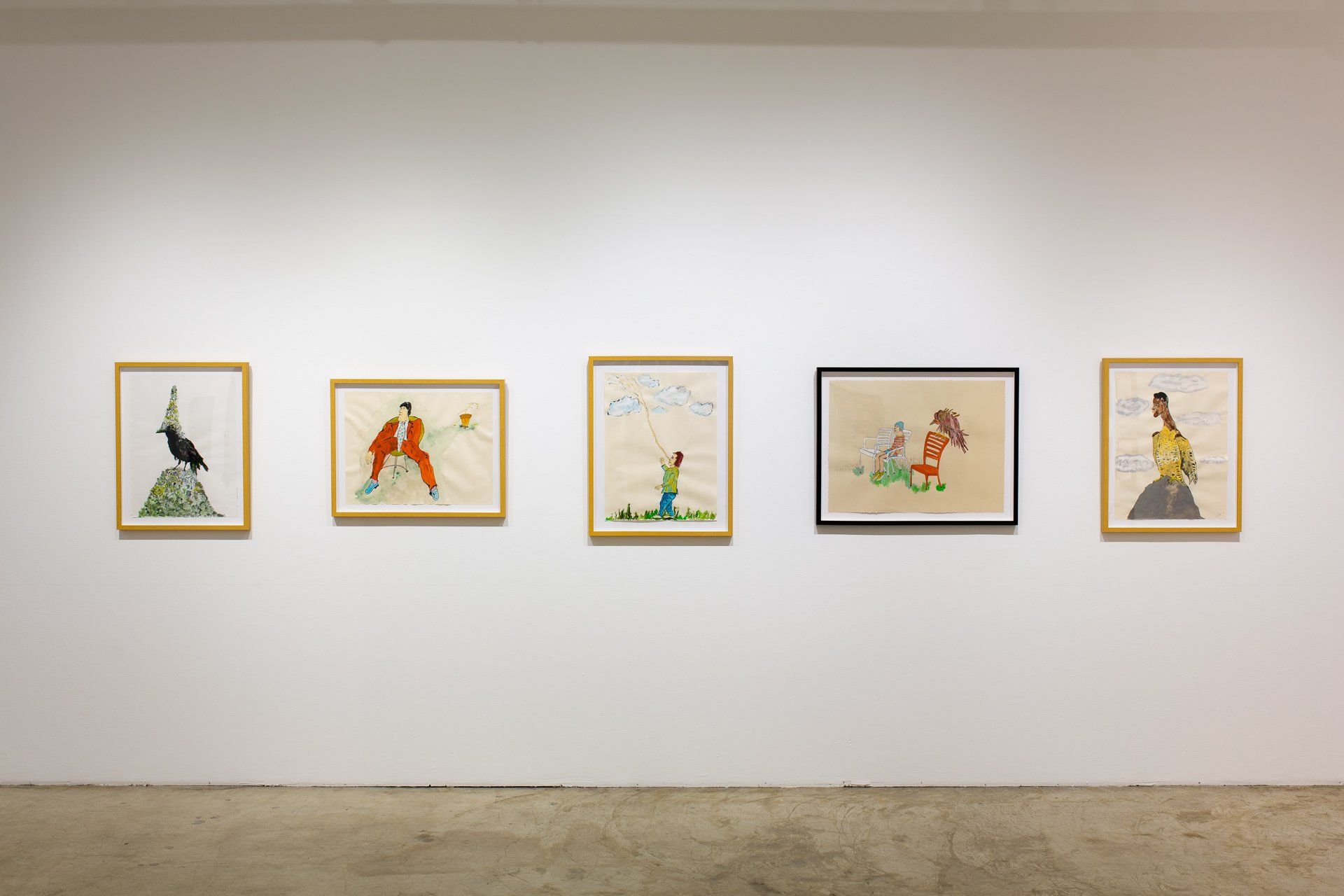 A row of paintings are hanging on a white wall in a museum.