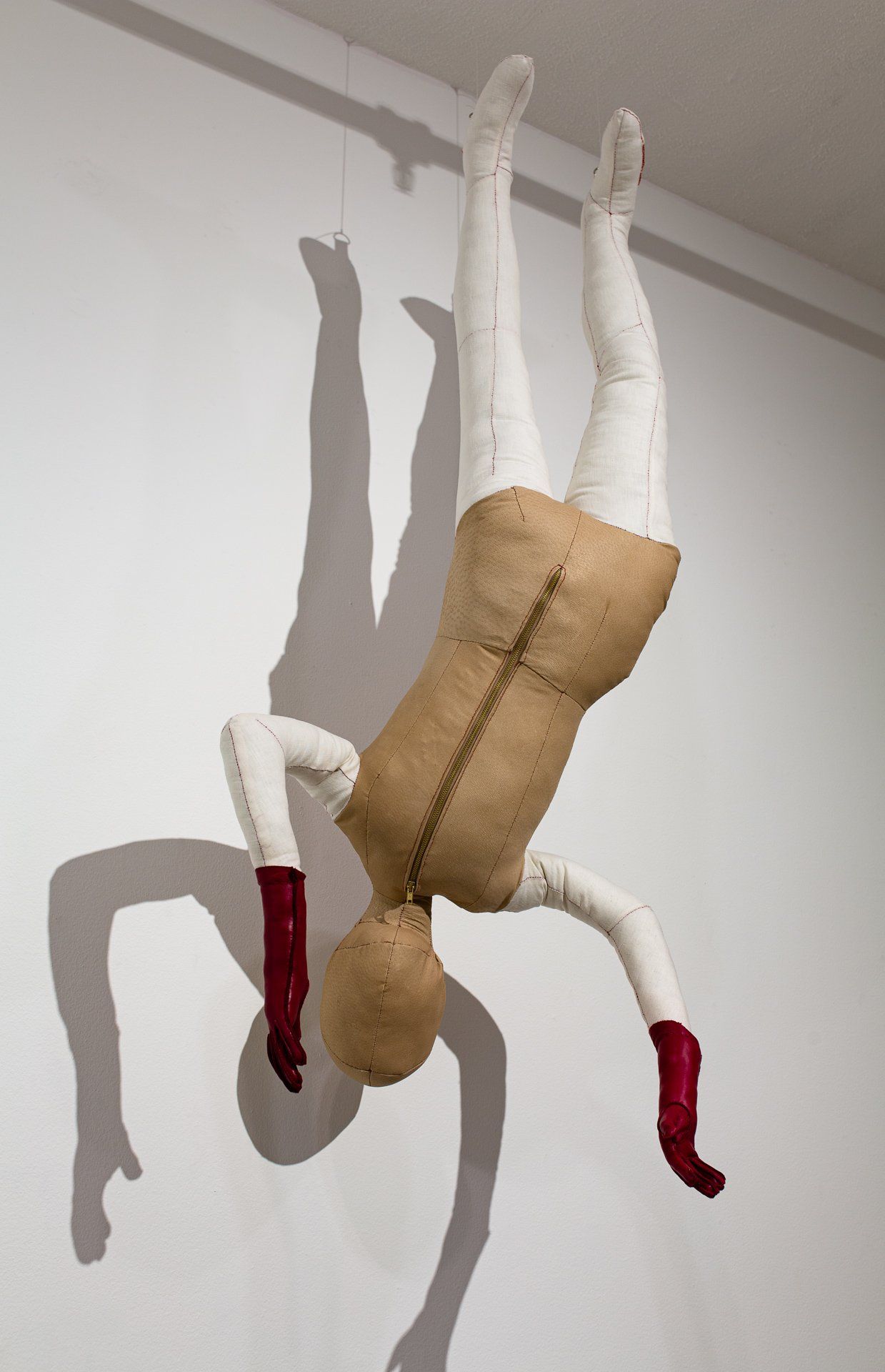 A mannequin is hanging upside down from the ceiling.