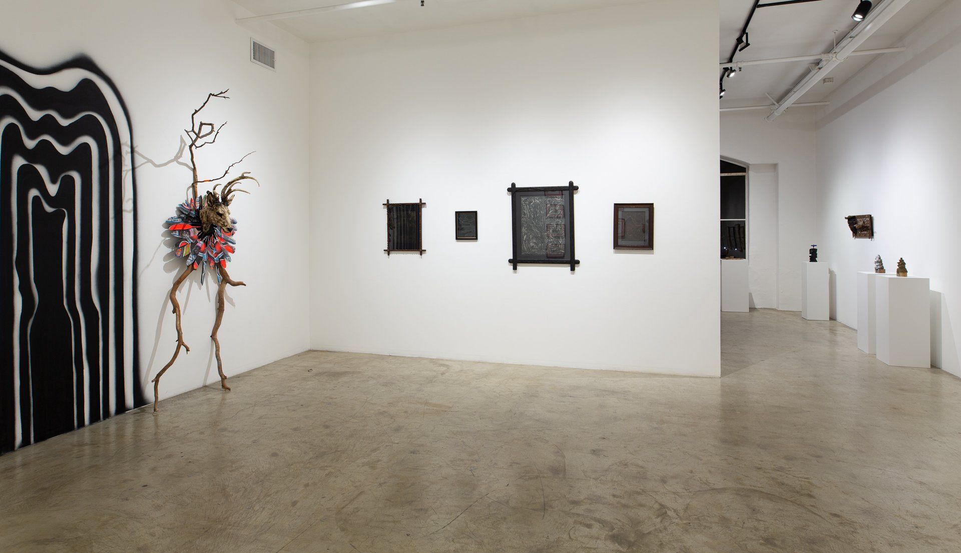 A large empty room with a few paintings on the wall