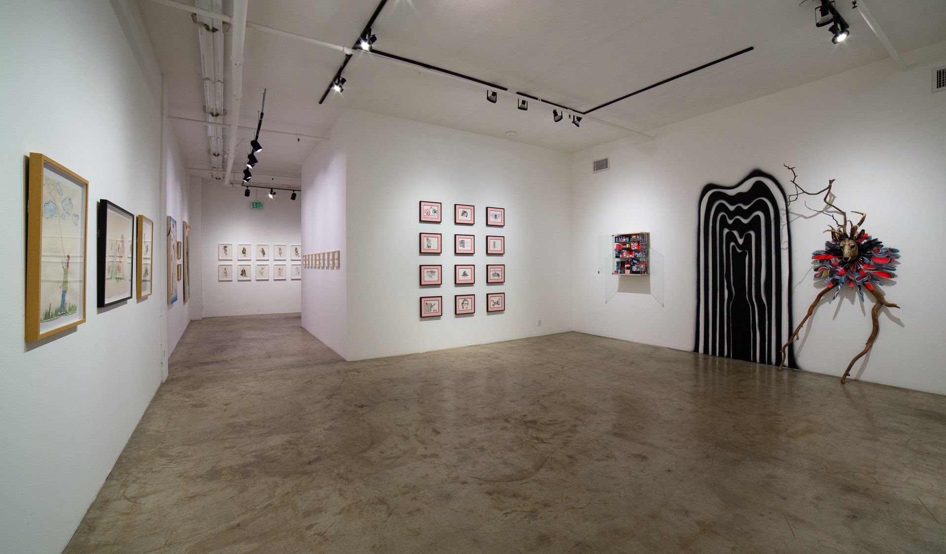 A large empty room with a lot of paintings on the walls.