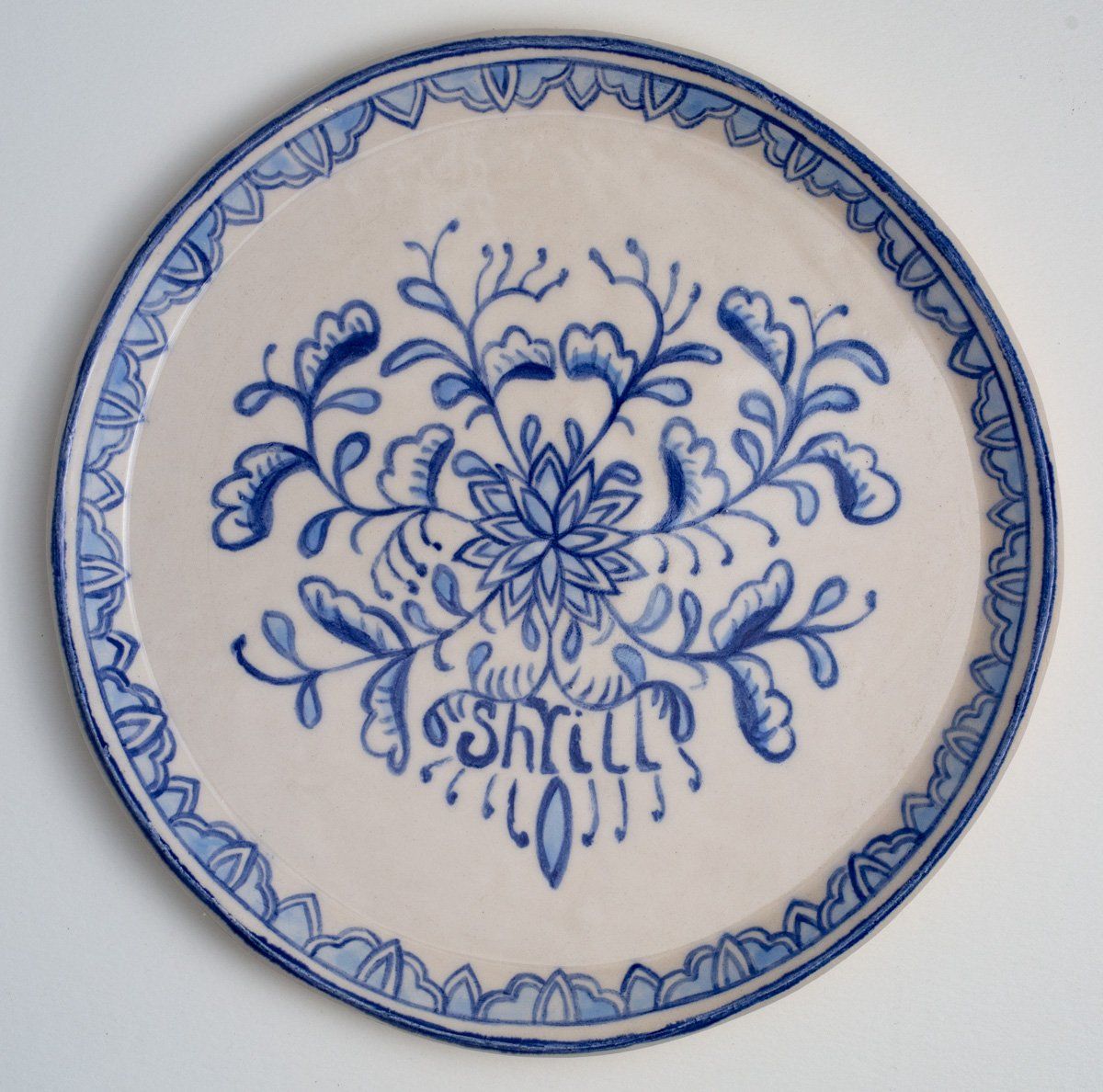 A blue and white plate with the word shells on it