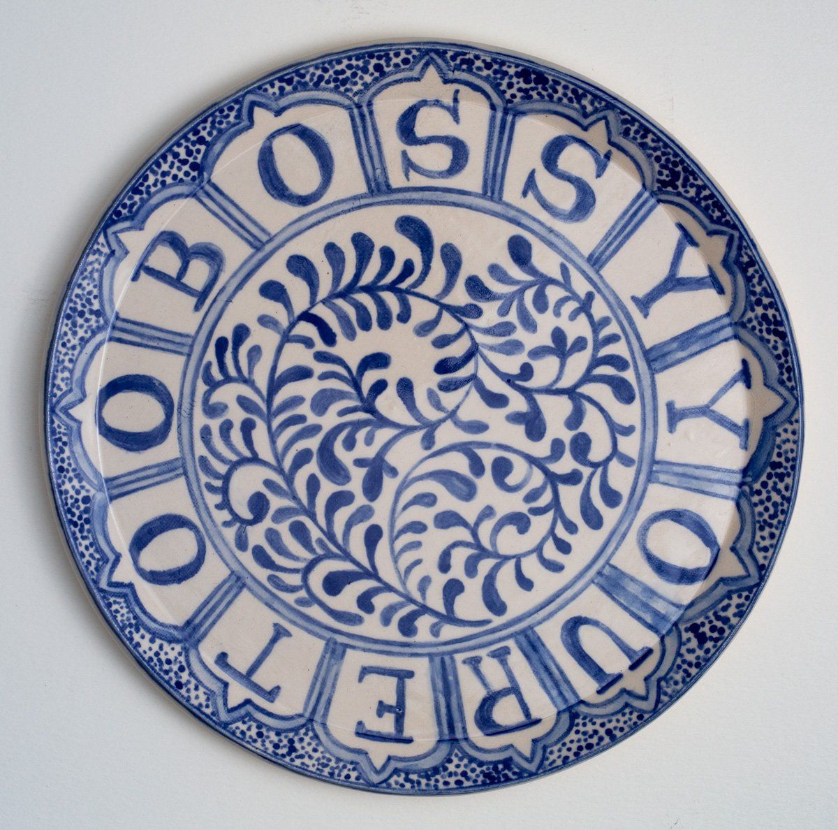 A blue and white plate with the word bossy on it