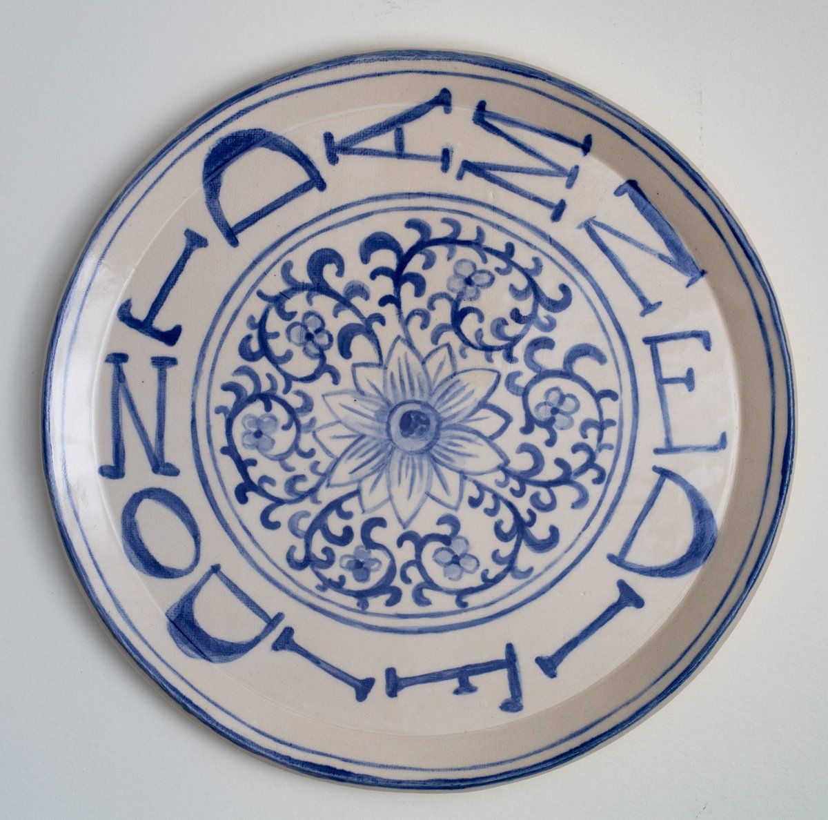 A blue and white plate with the word dan on it