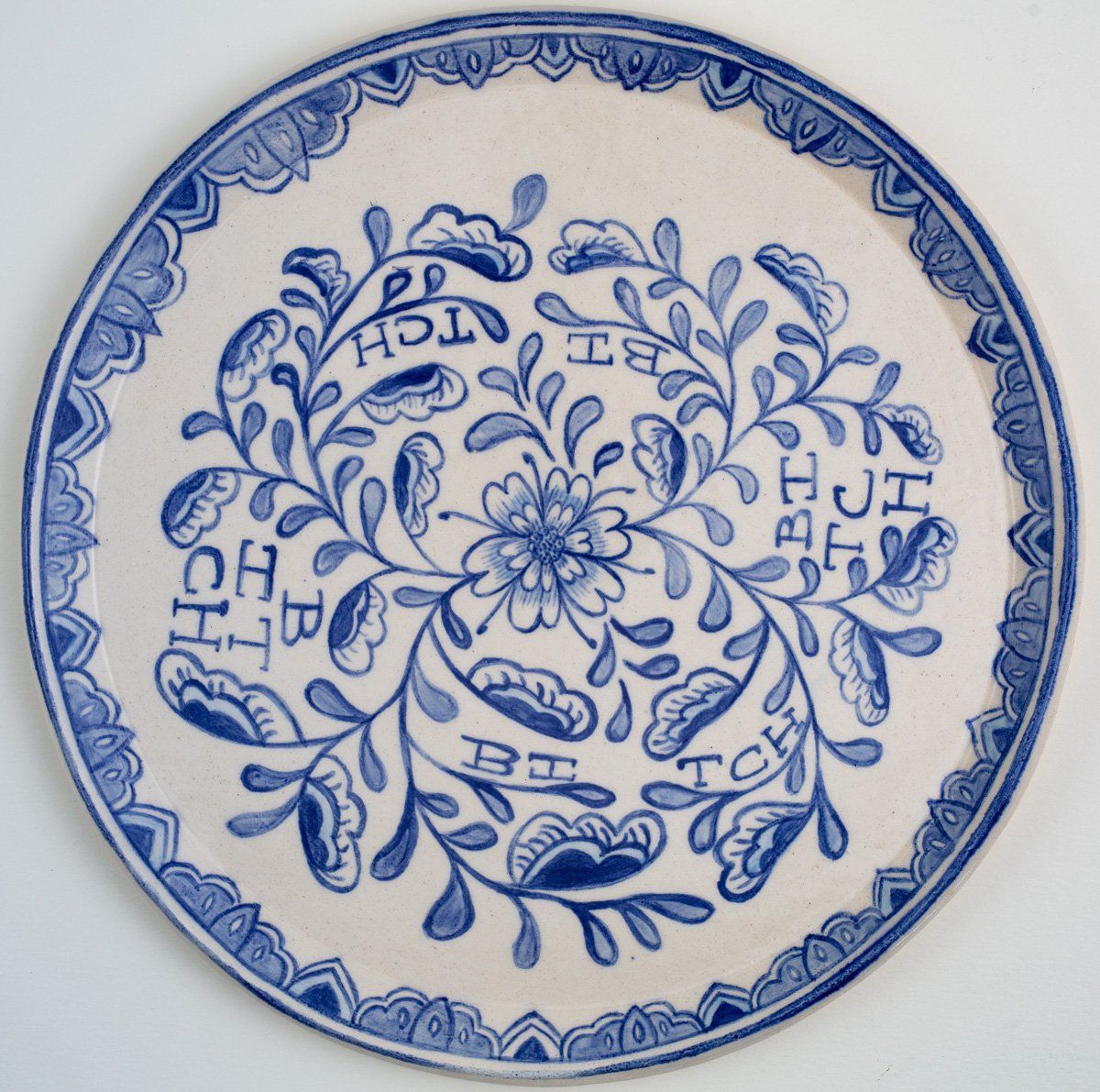 A blue and white plate with the letters jh on it